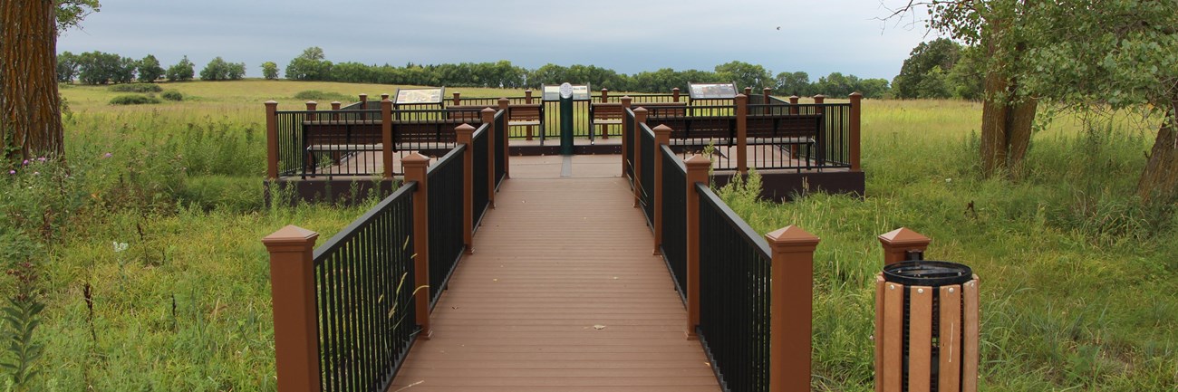 A wheelchair accessible ramp leads from the trail up to a platform that overlooks the prairie.