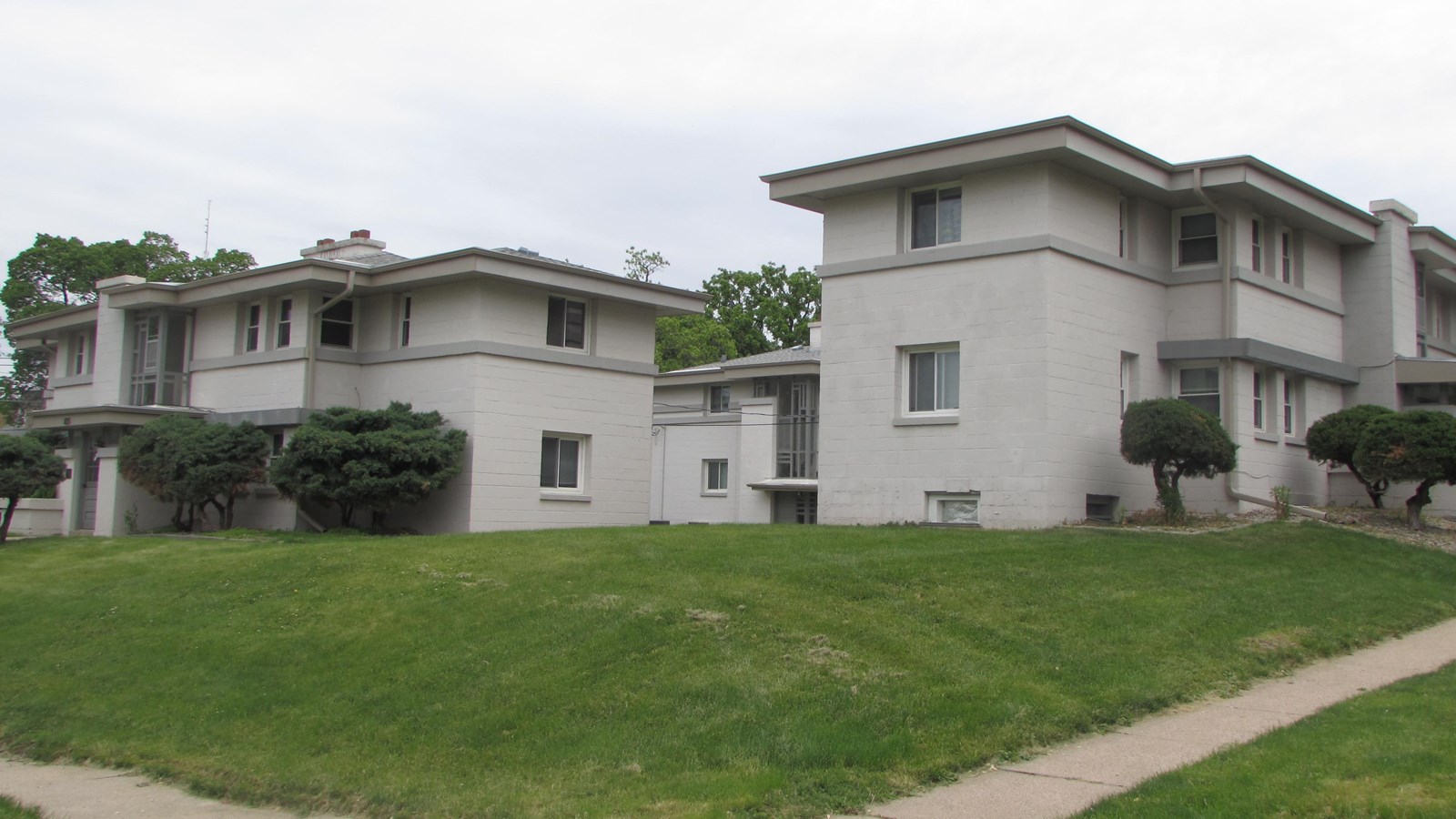 Two-story concrete apartment buildings. Three buildings with center courtyard.