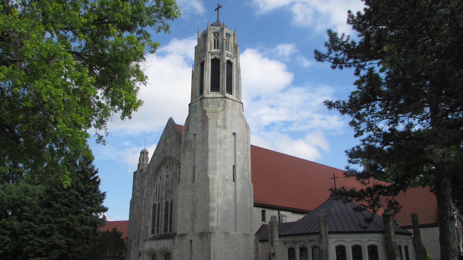 English rural gothic style church, center gable, tower on right front. Accessory buildings attached.