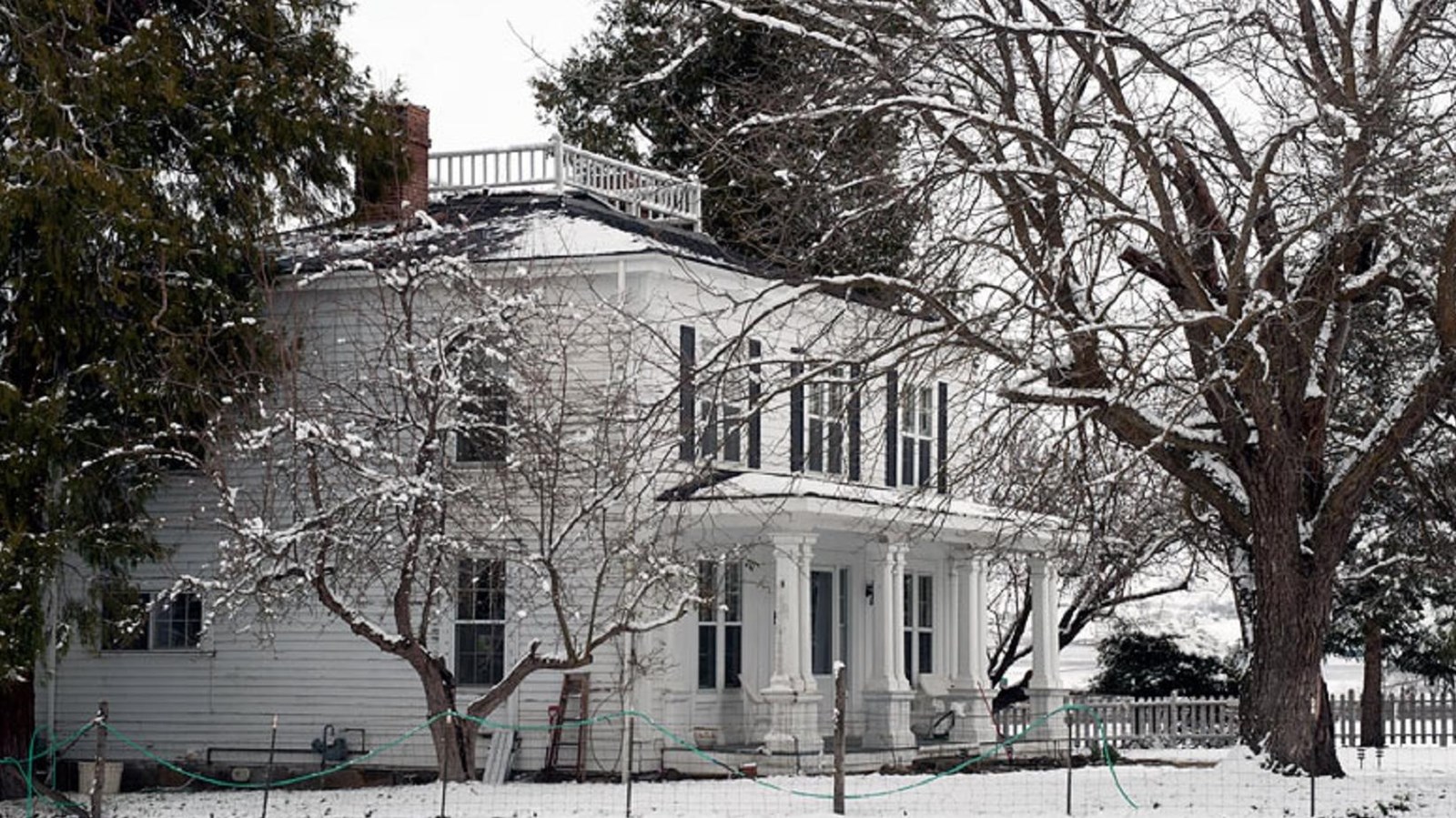 Large white house covered in snow.