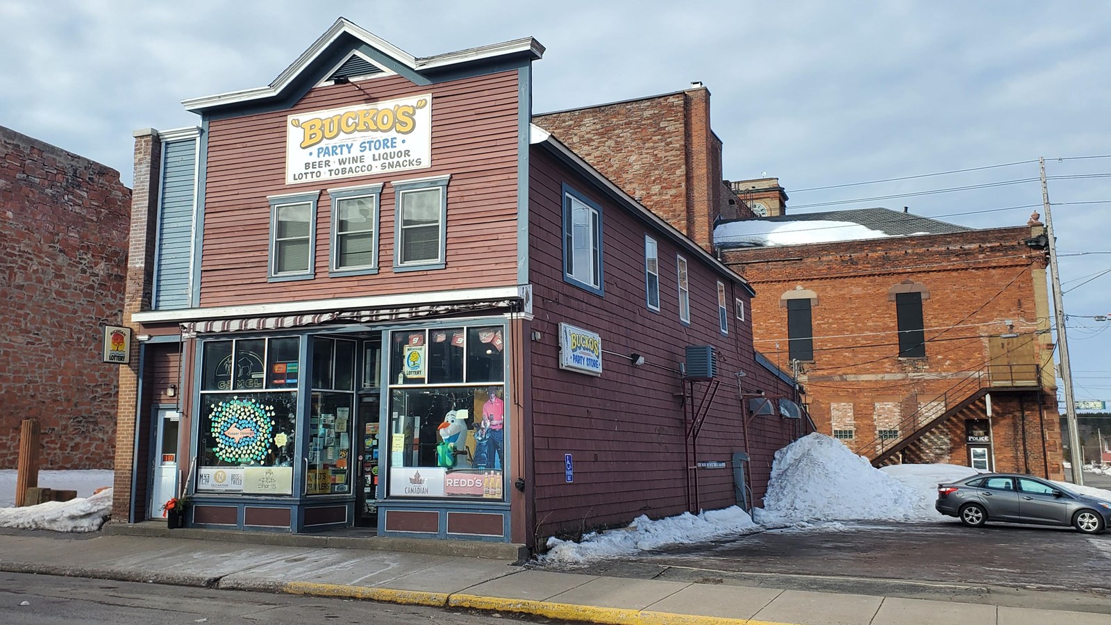 Two-story wood-frame building with false front and red wooden siding.