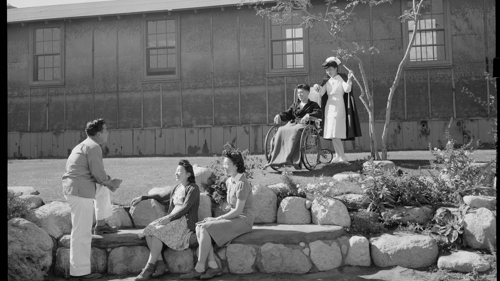 Black and white photo of Japanese Americans in front of the Manzanar Hospital, 1943