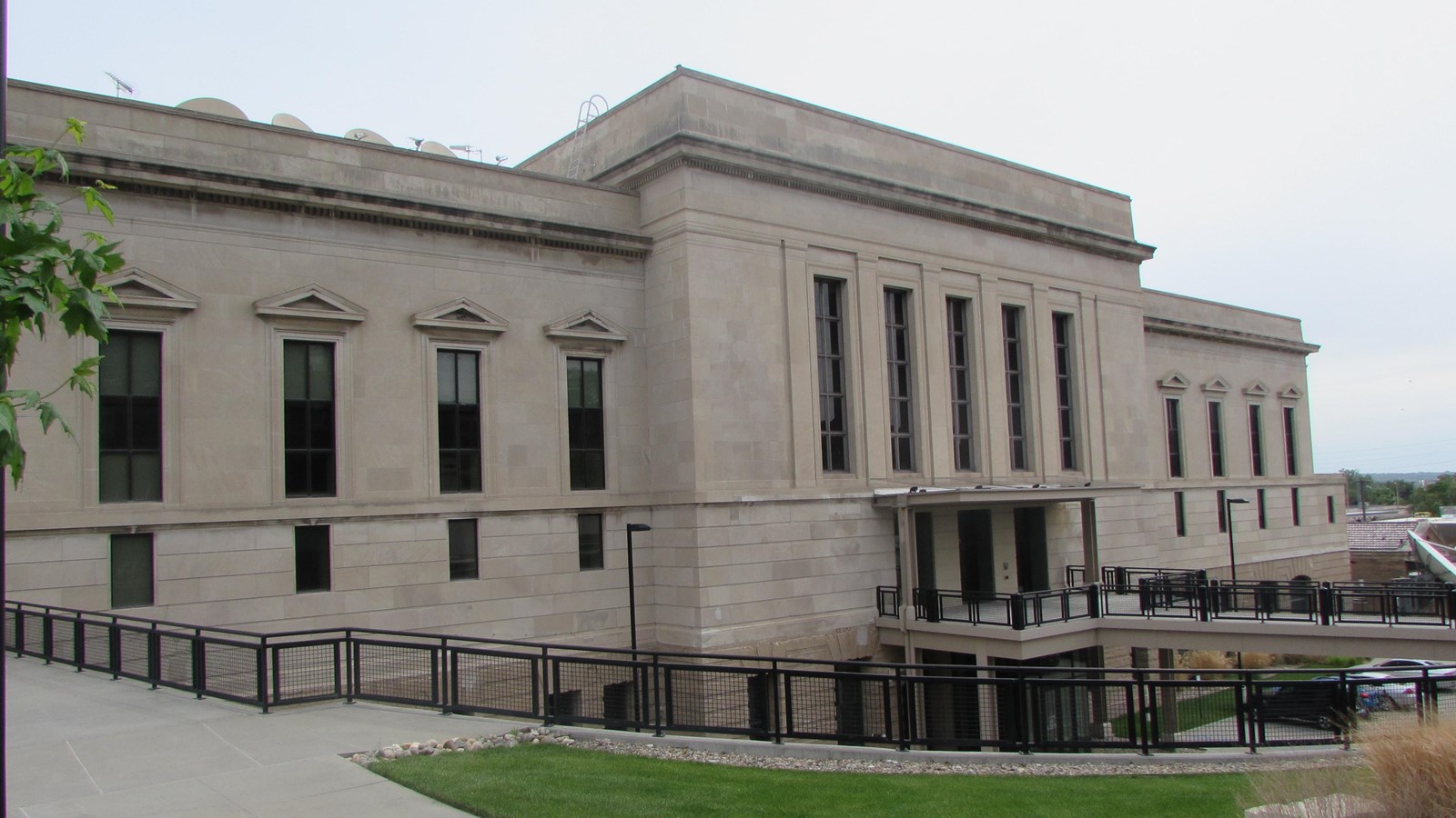 Neo-classical building with tall, vertical windows. Center mass with two large wings.