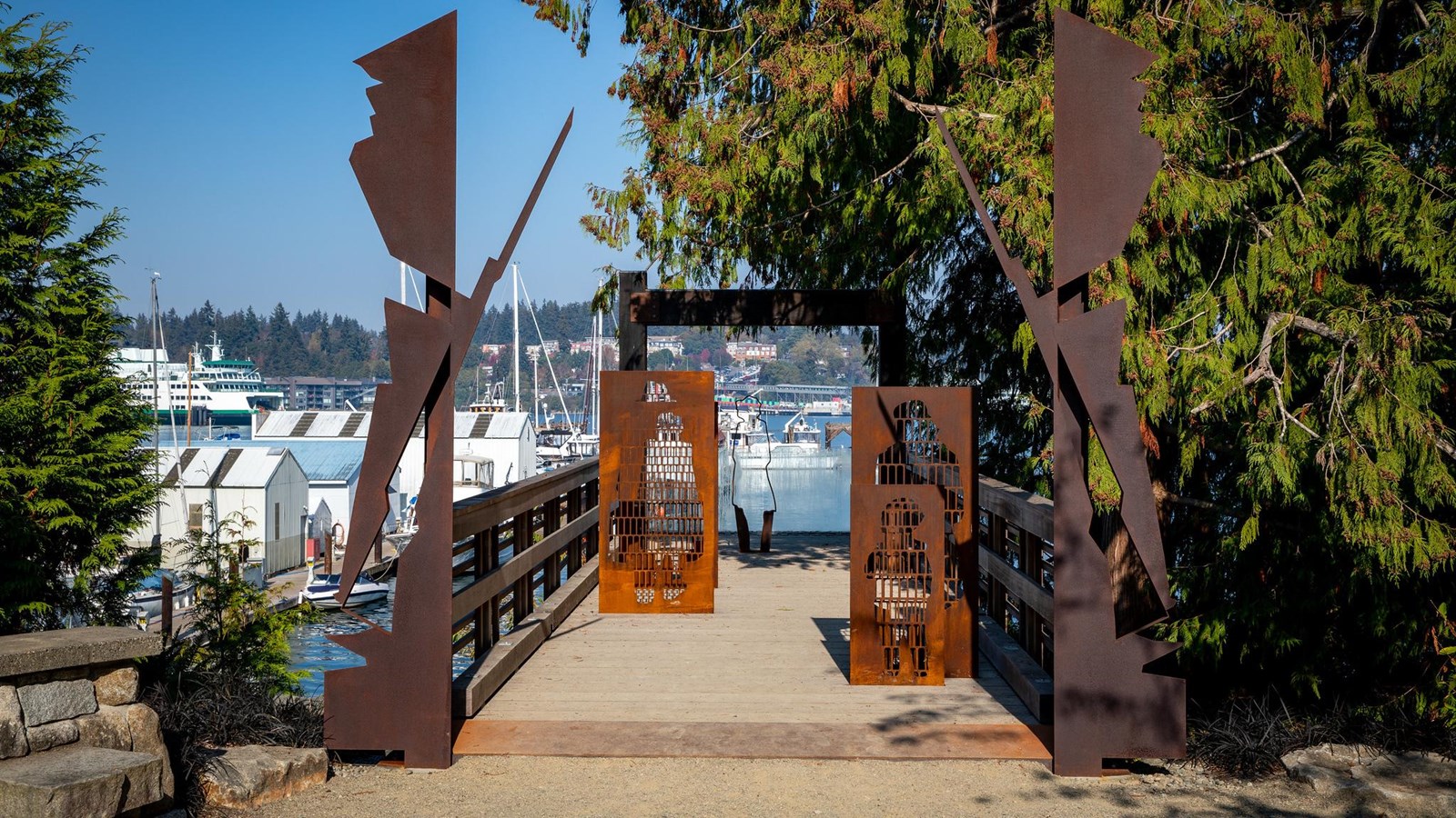 Dock with metal sculptures leading out into a harbor.