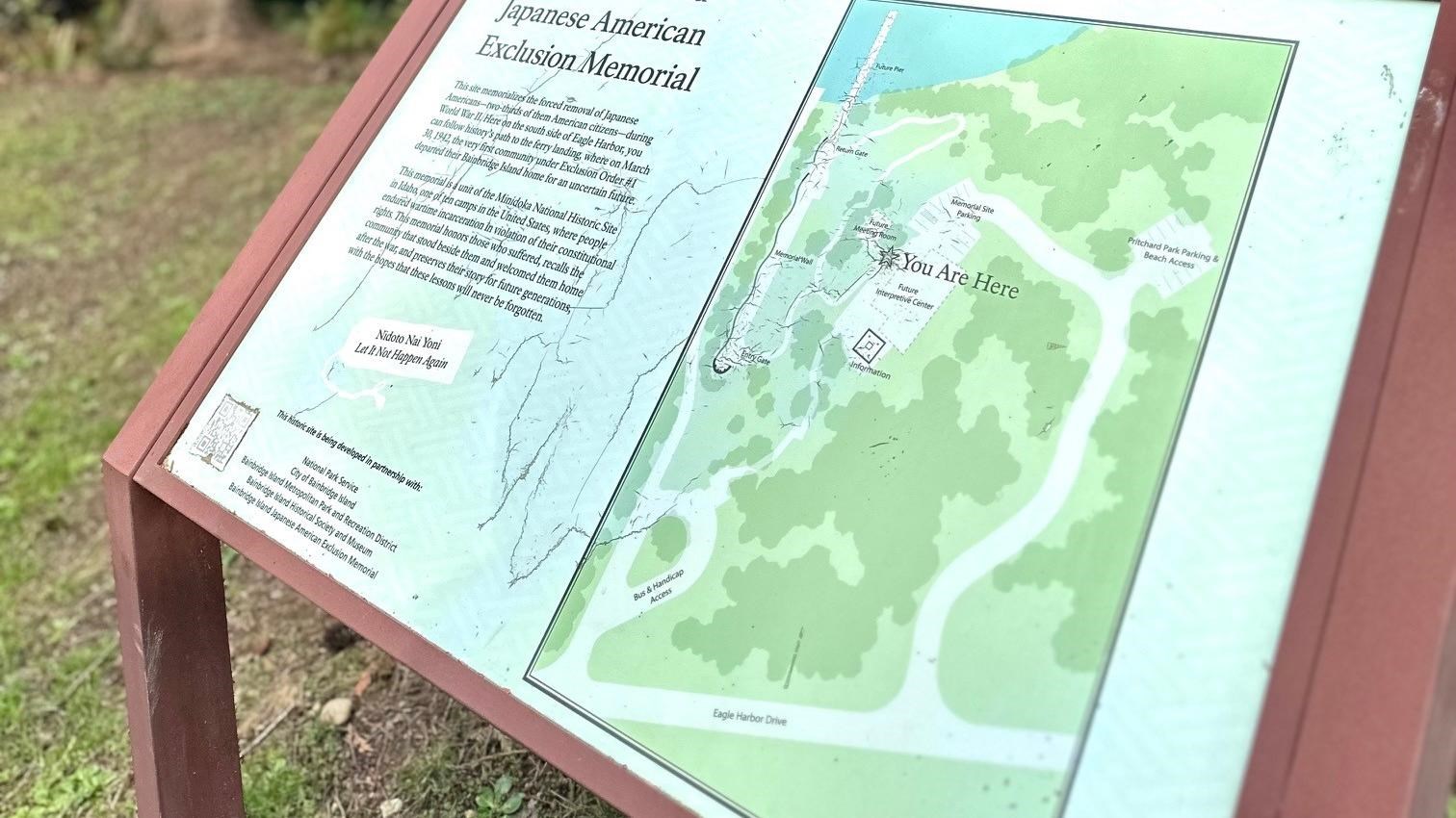 Map of Japanese American Exclusion Memorial against a bush.