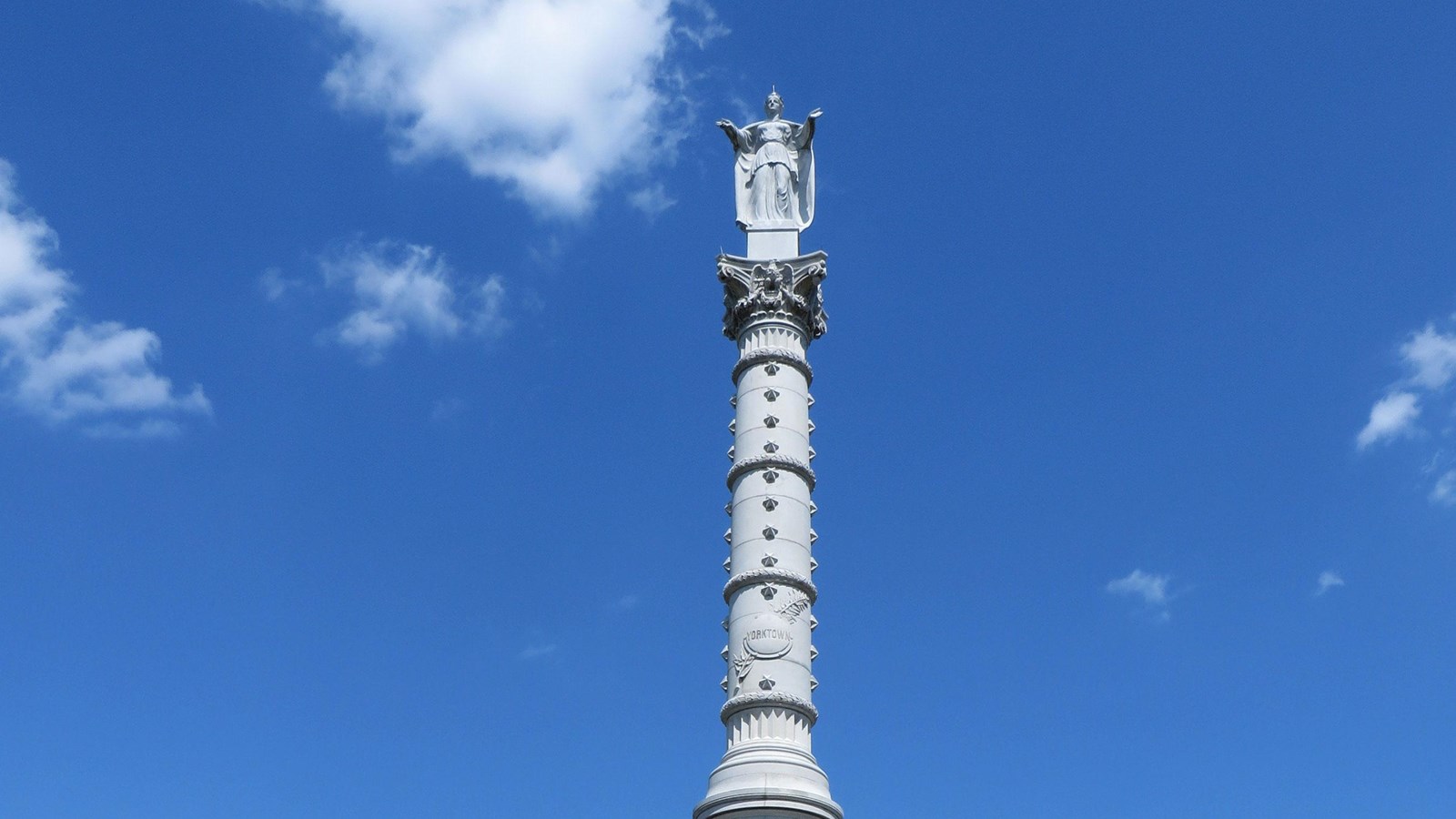 A 100 foot white granite monument with various symbols of the victory and the Lady Liberty on top.