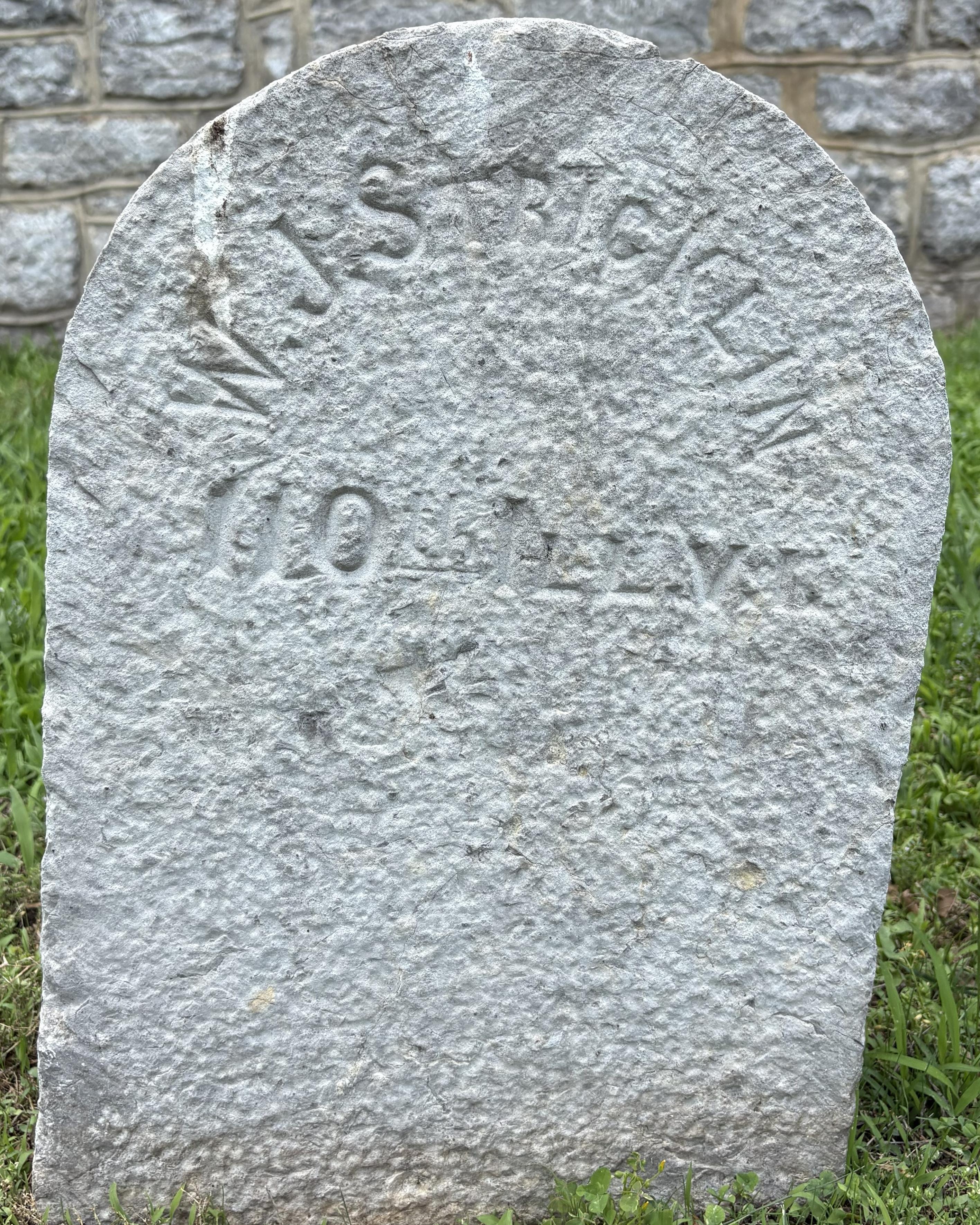 Stone headstone with the name "W. J. Stricklin" inscribed on its face.