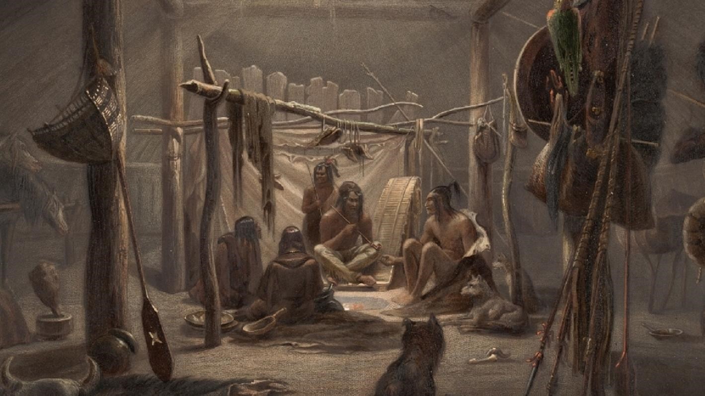 The inside of an earthlodge, 5 people around fire in the center, 2 horses are to the left.