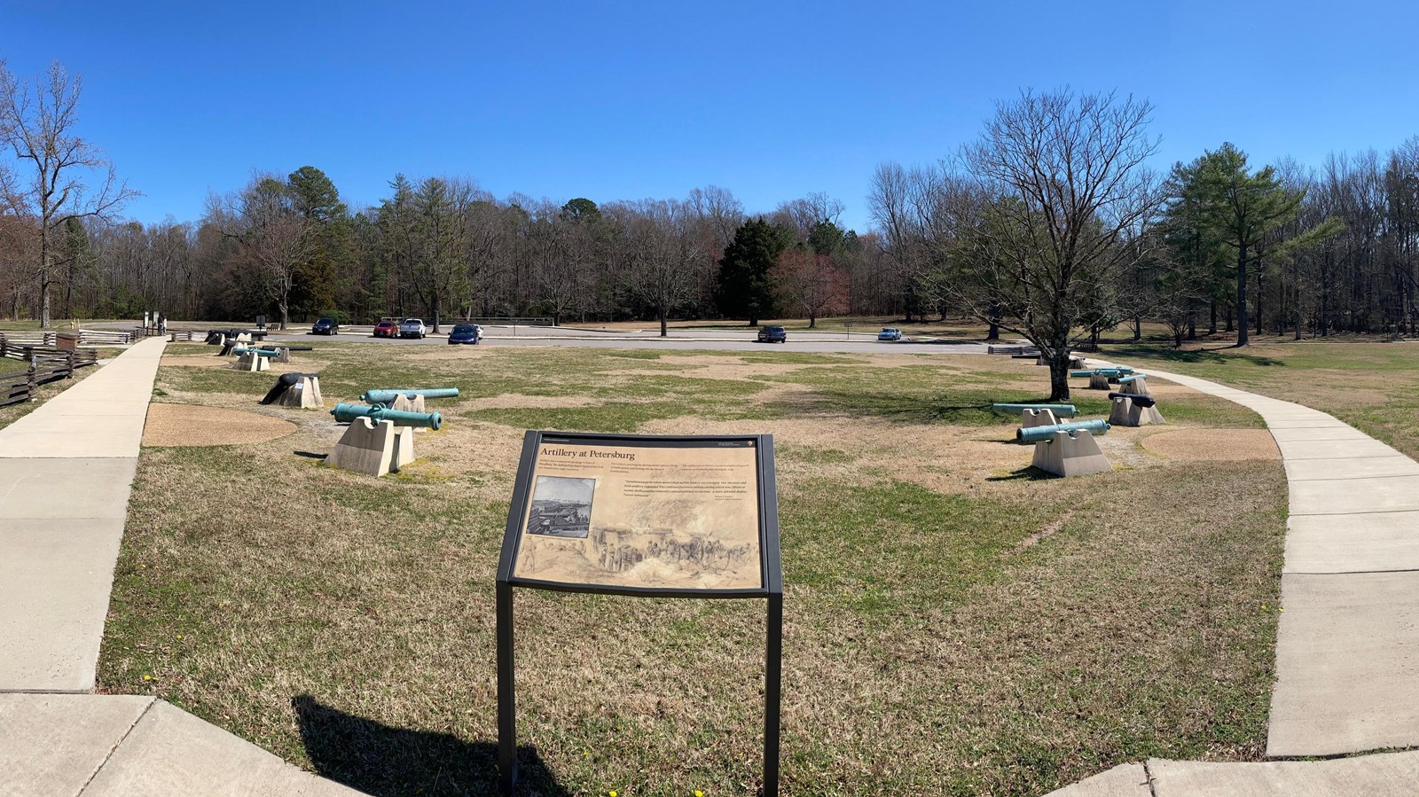 Six groups of three cannon tubes line sidewalks leading away from the a wayside.