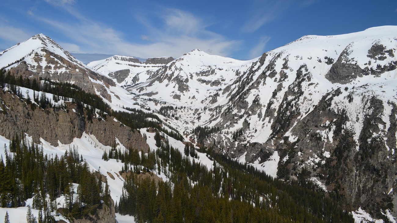 A mountainous canyon covered in patchy snow.