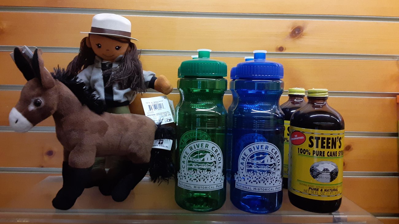 A display of items for purchase including toys, water bottles, and cane syrup.