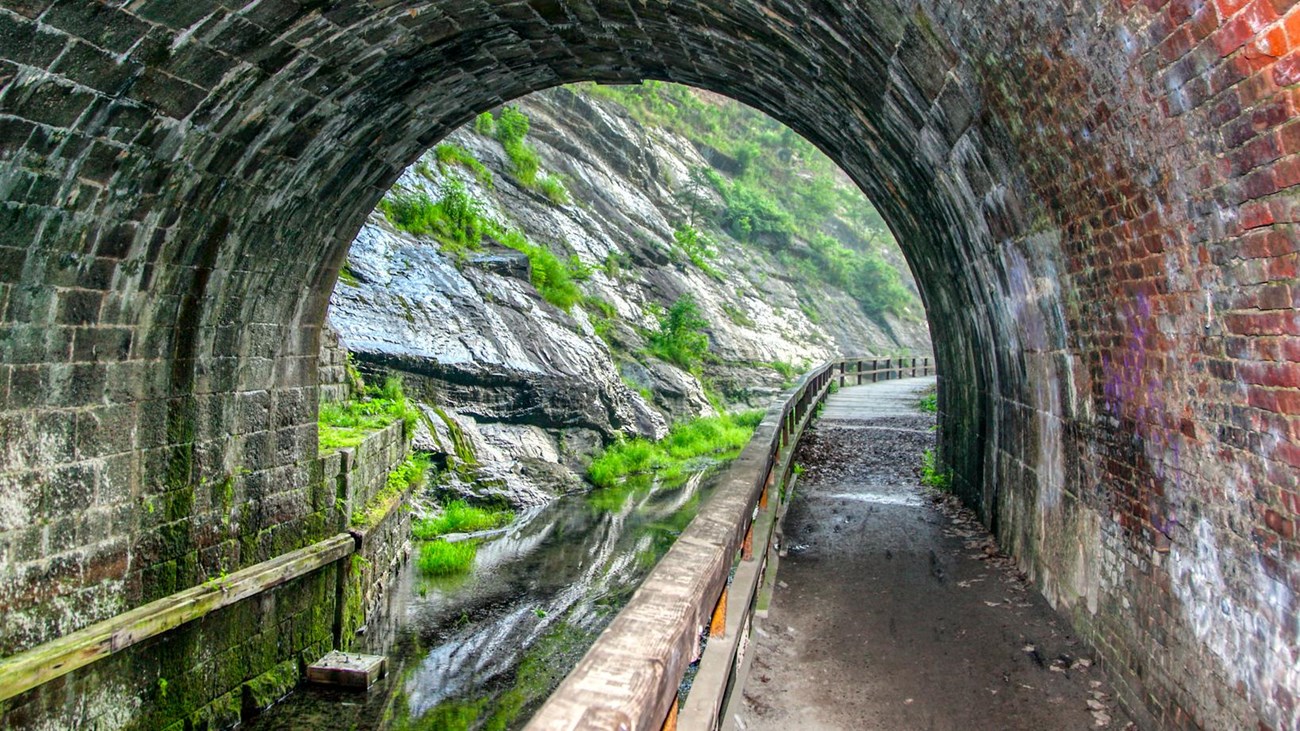 inside view of a brick tunnel next to a canal