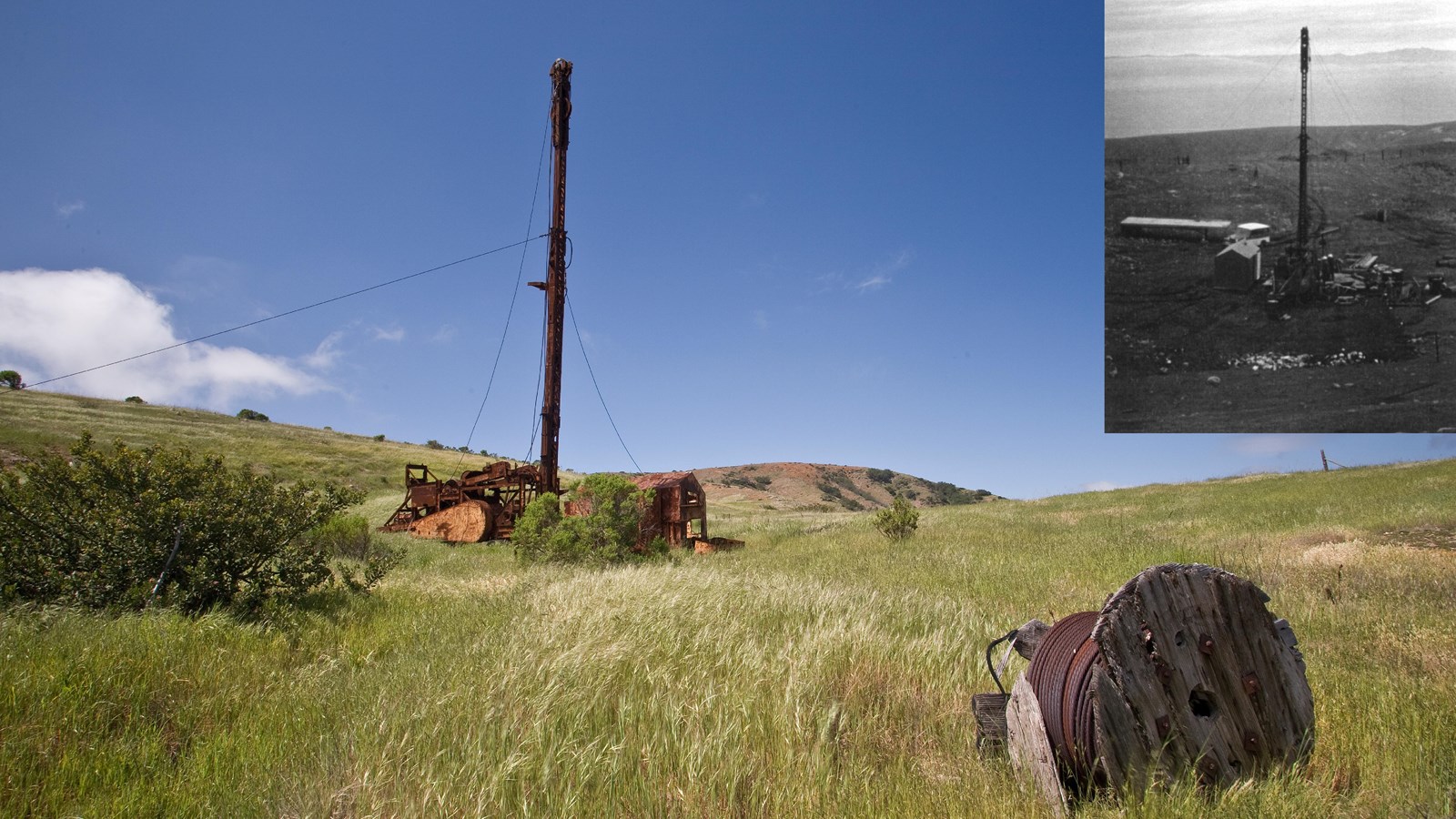 rusting oil well with cables supporting the drill. cable lying in grass. 