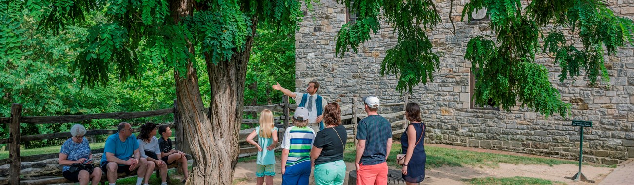A living history interpreter shows visitors what it would have been like to run the gristmill.