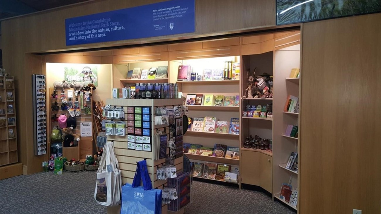 A retail space with books and other items for purchase shown on shelves and racks