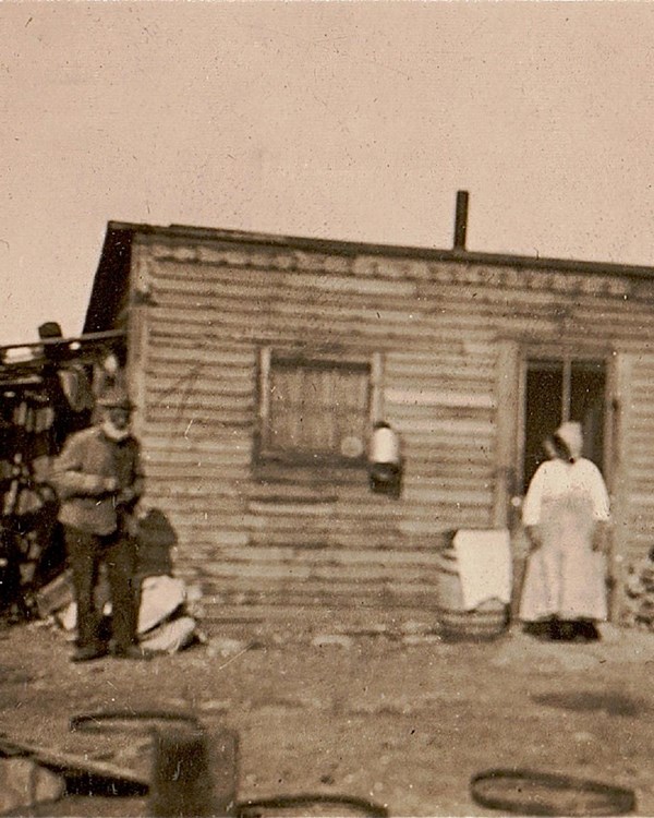 a man and women outside of a small house