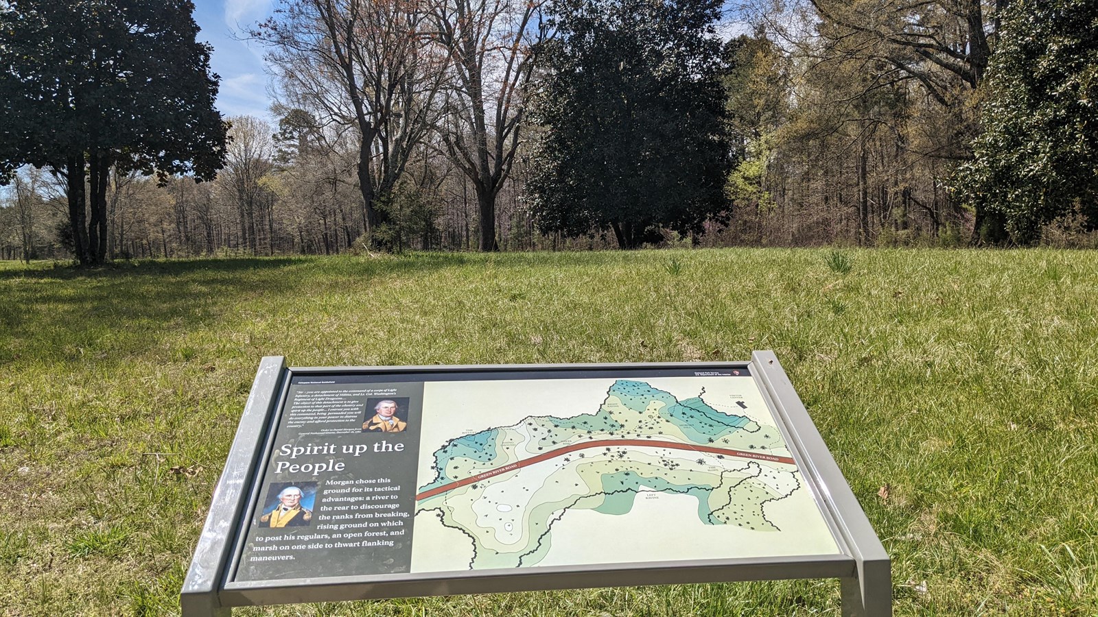 Way side on the right of the trail in the middle of a field with sparse trees.