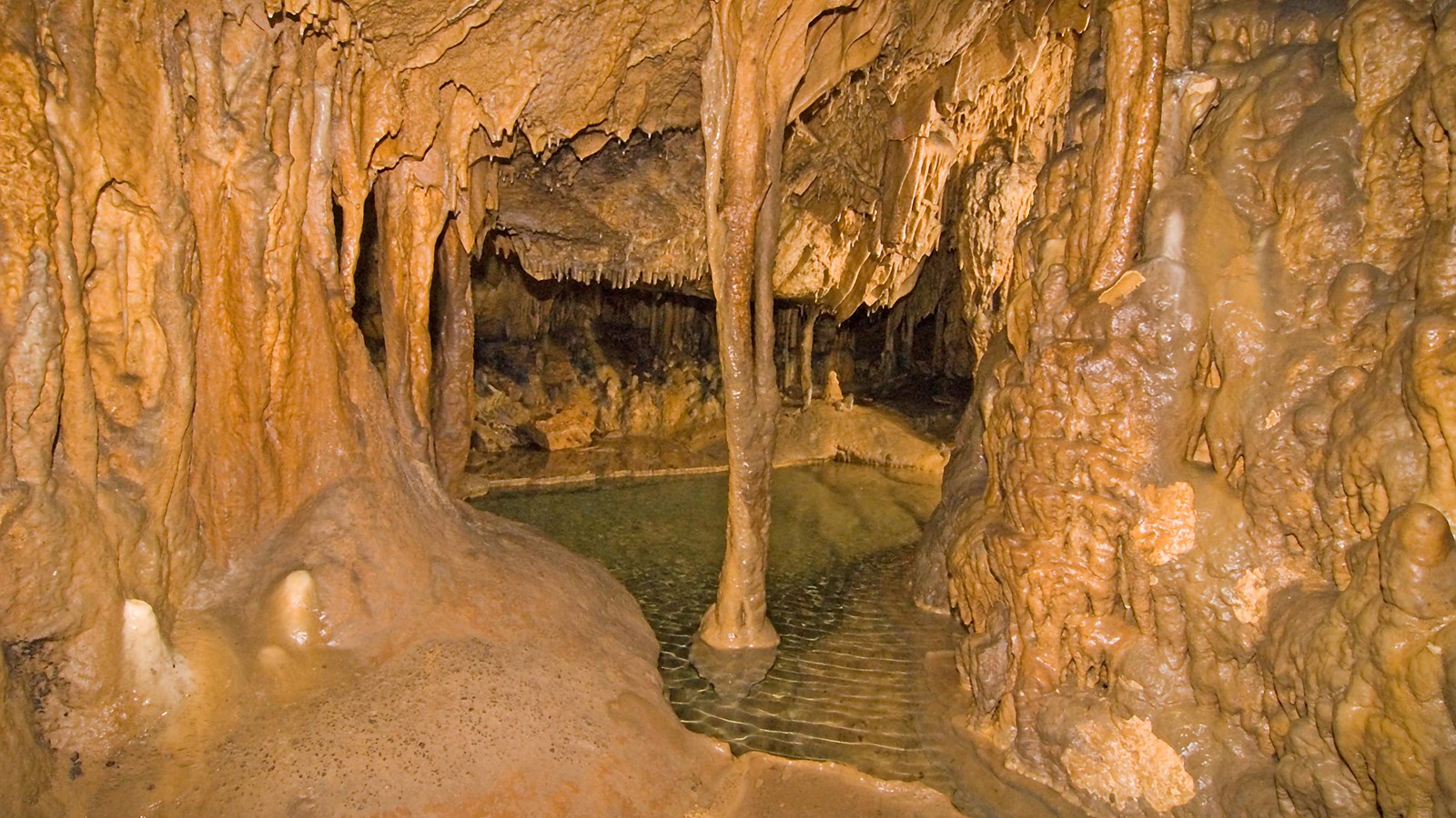 Cave formation with water at the bottom of it.