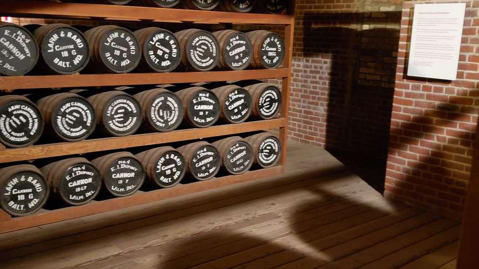 A shelf lined with wooden barrels on their sides.