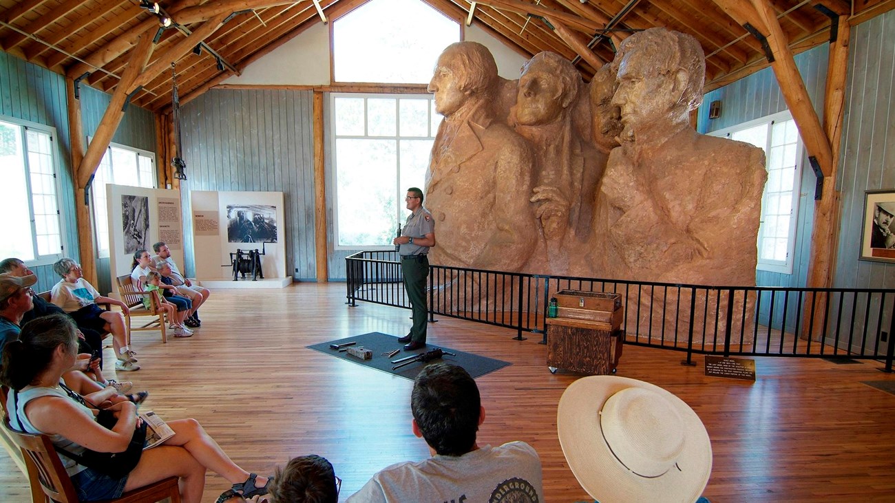 Photo of the interior of the Sculptor\'s Studio during a ranger talk, the scale model is in the back.