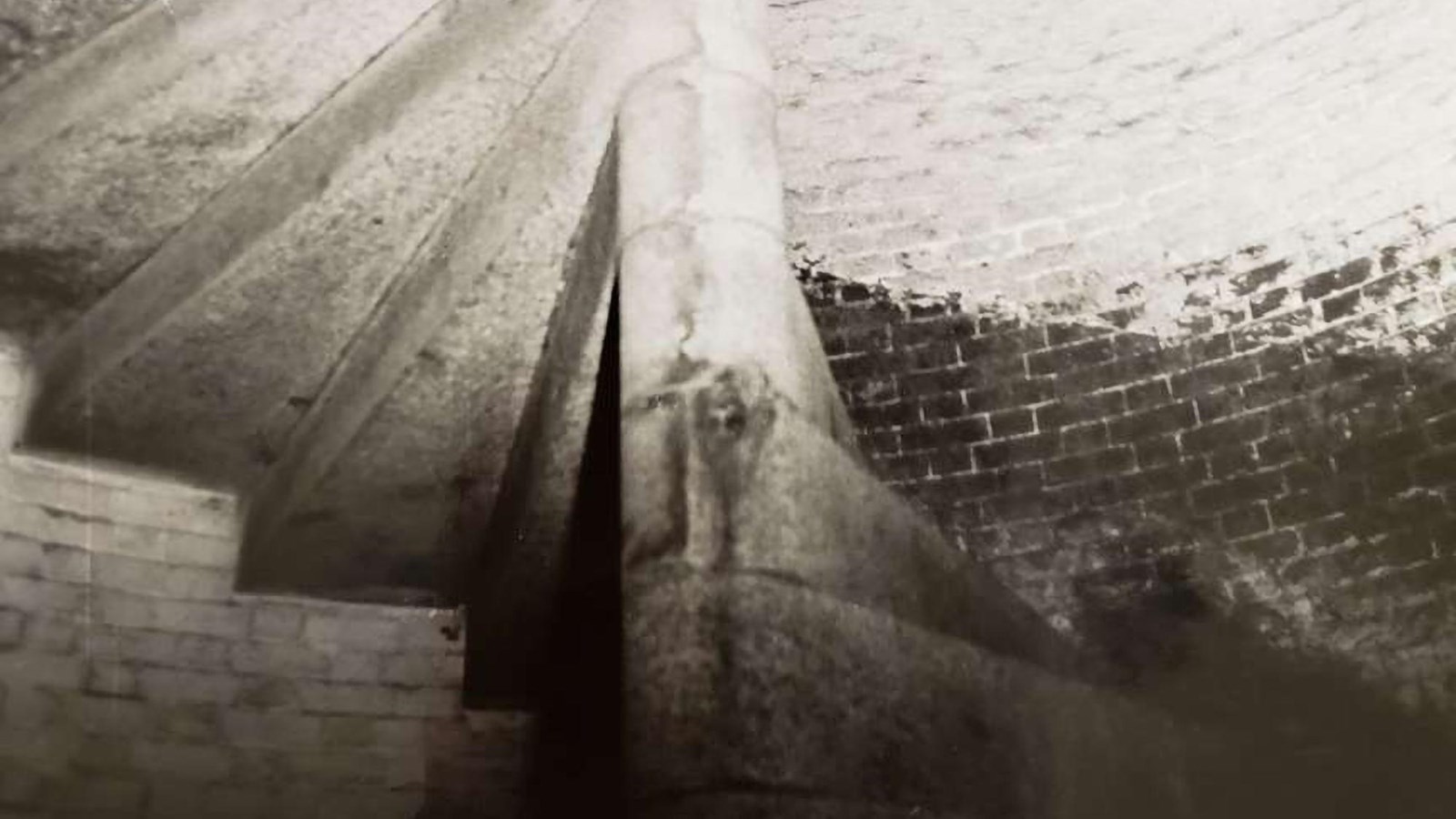 Black and white images of large granite steps in a brick tower form a spiral staircase.