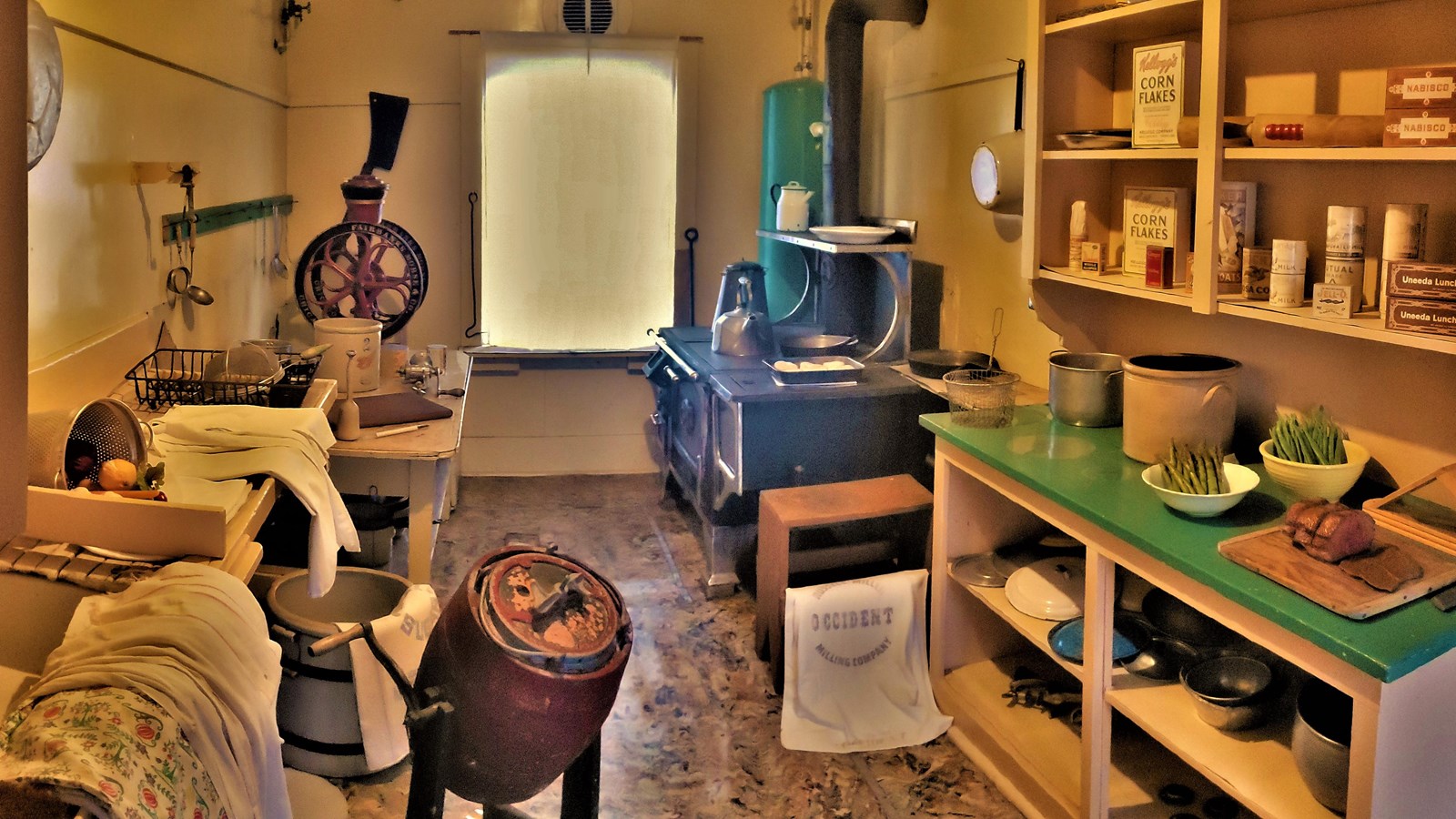 A large stove and several items used for preparing meals are on display in the bunkhouse kitchen.