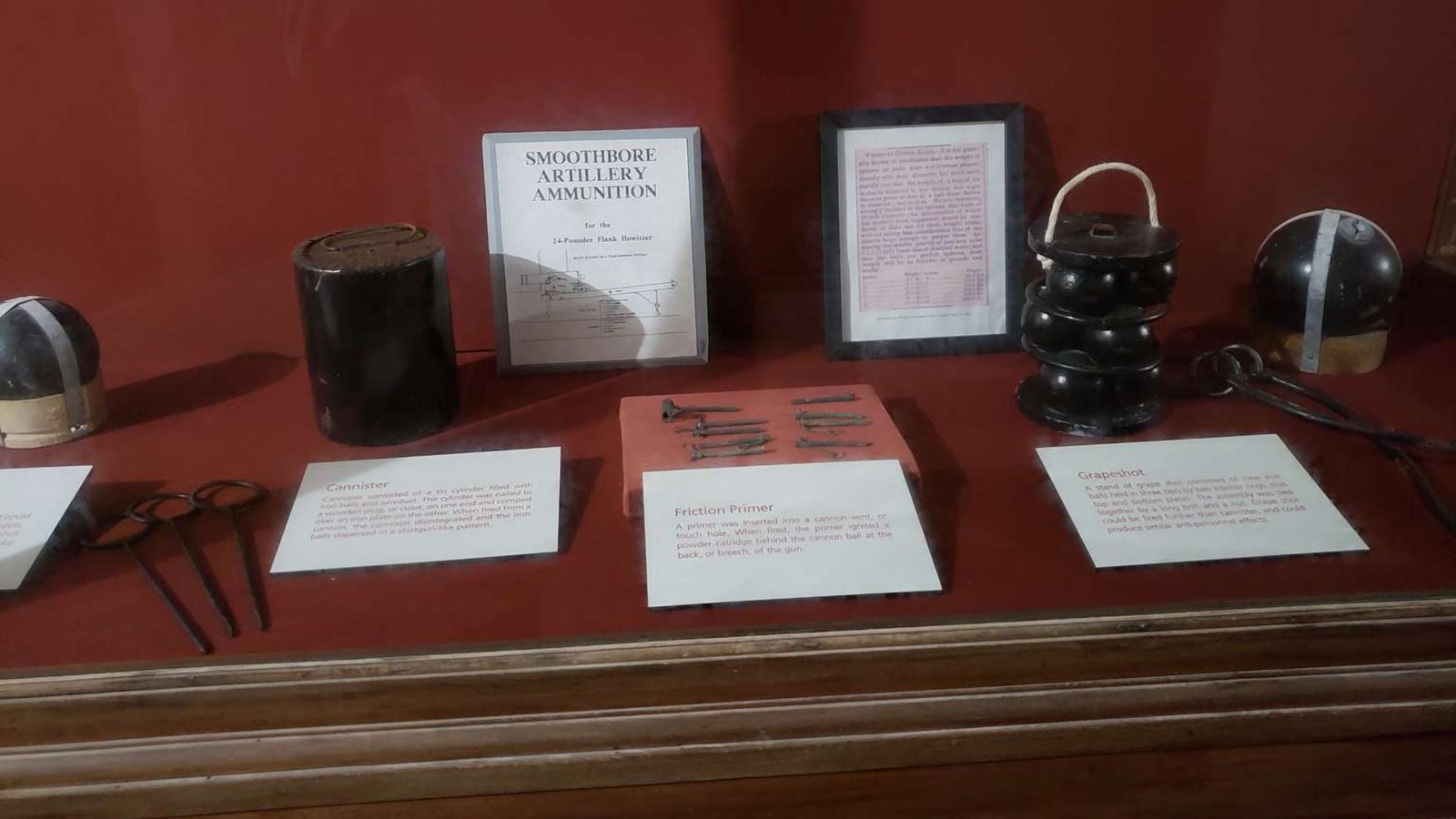 A display table containing various artillery ammunition and signage explaining their uses.