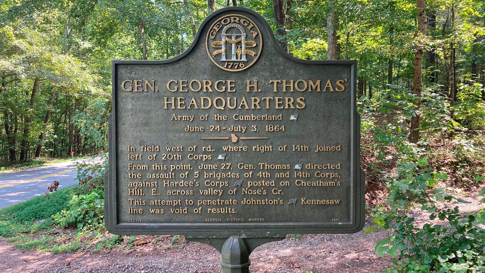 A green tinged bronze sign in a wooded area marks the location of Gen. Thomas\'s headquarters