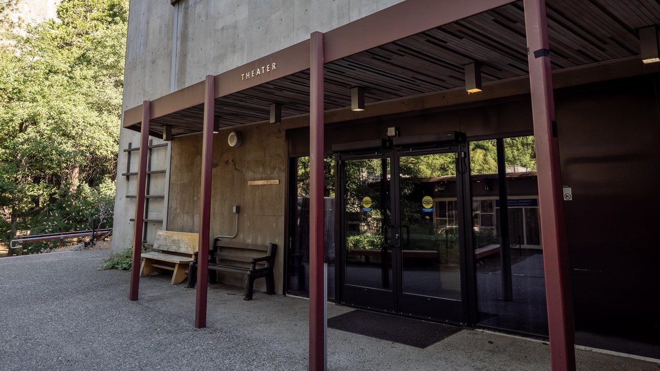 A covered entryway leads to glass double doors; lettering above the entryway reads