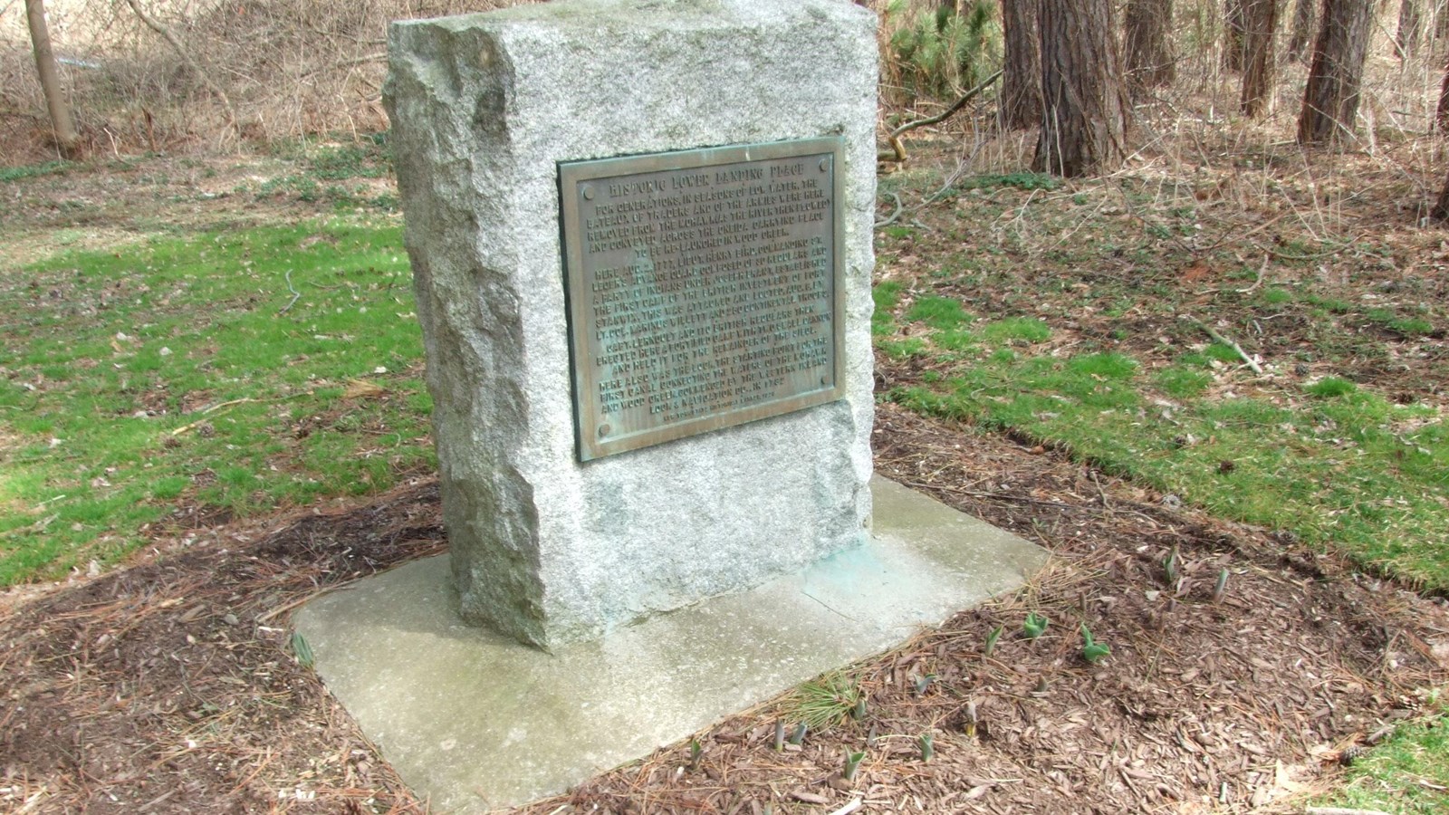 A granite marker with a brass plaque 