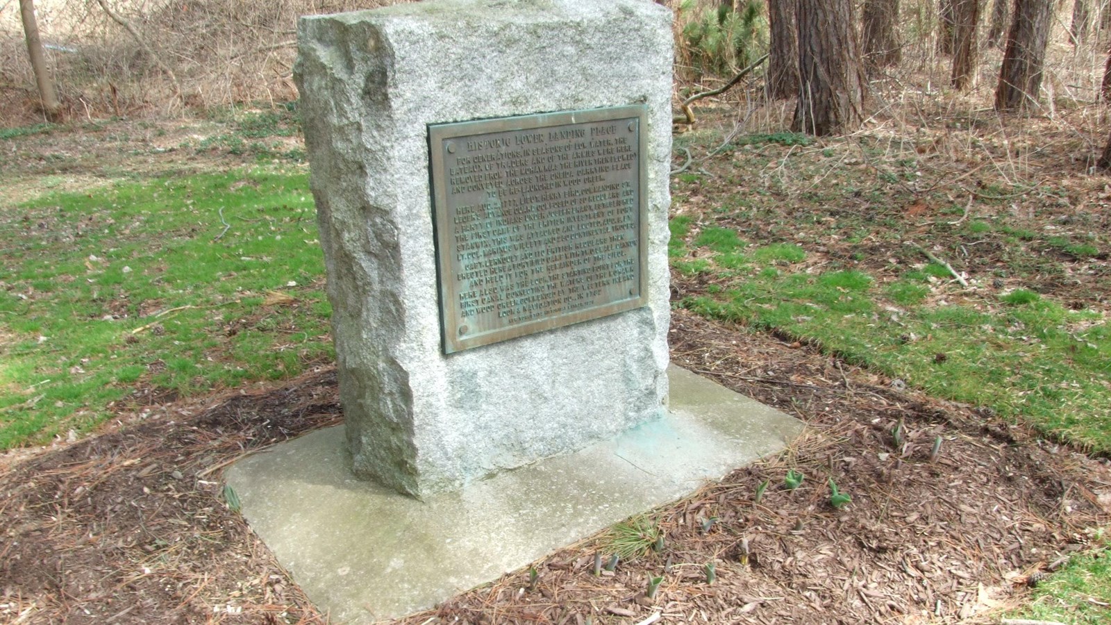 A granite marker with a brass plaque