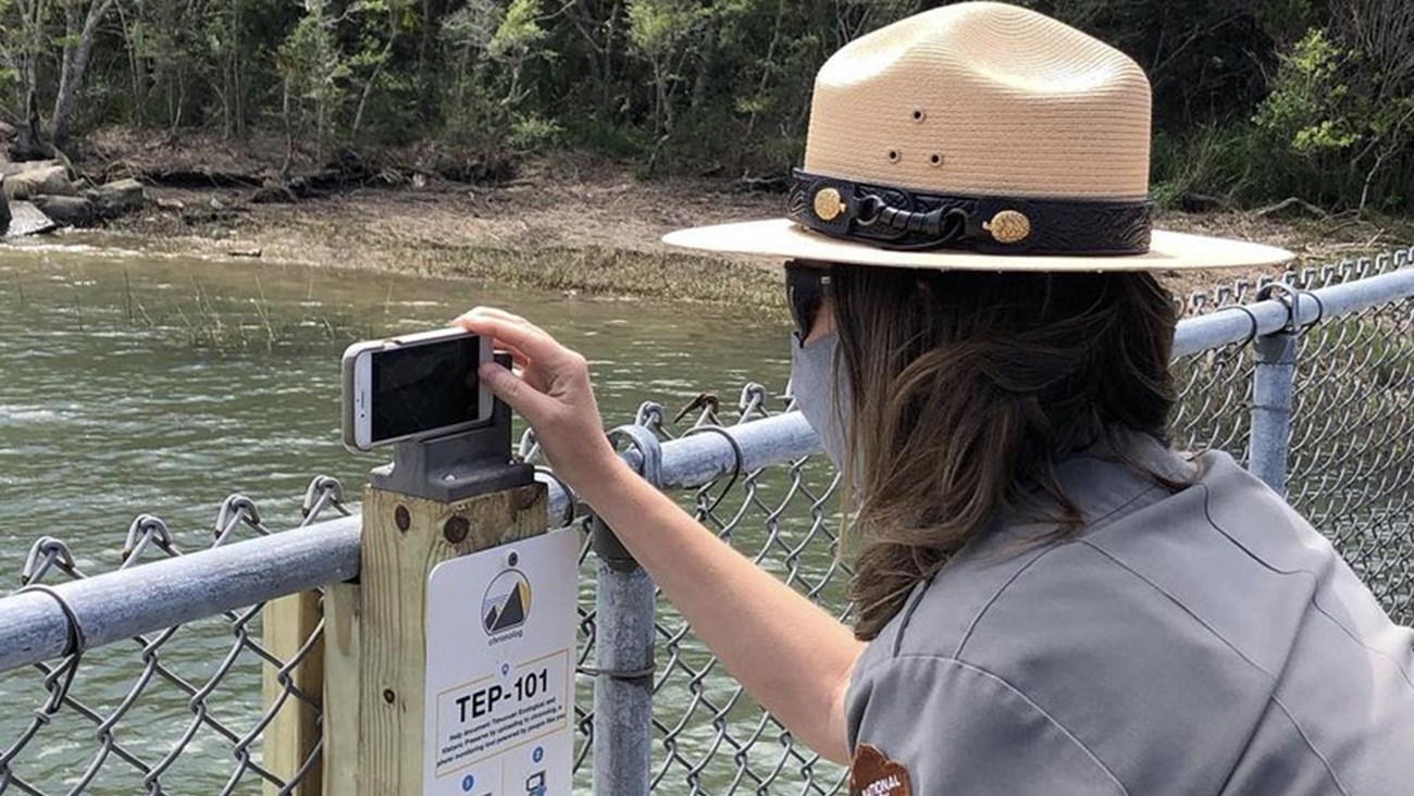 a ranger takes a photo on the dock