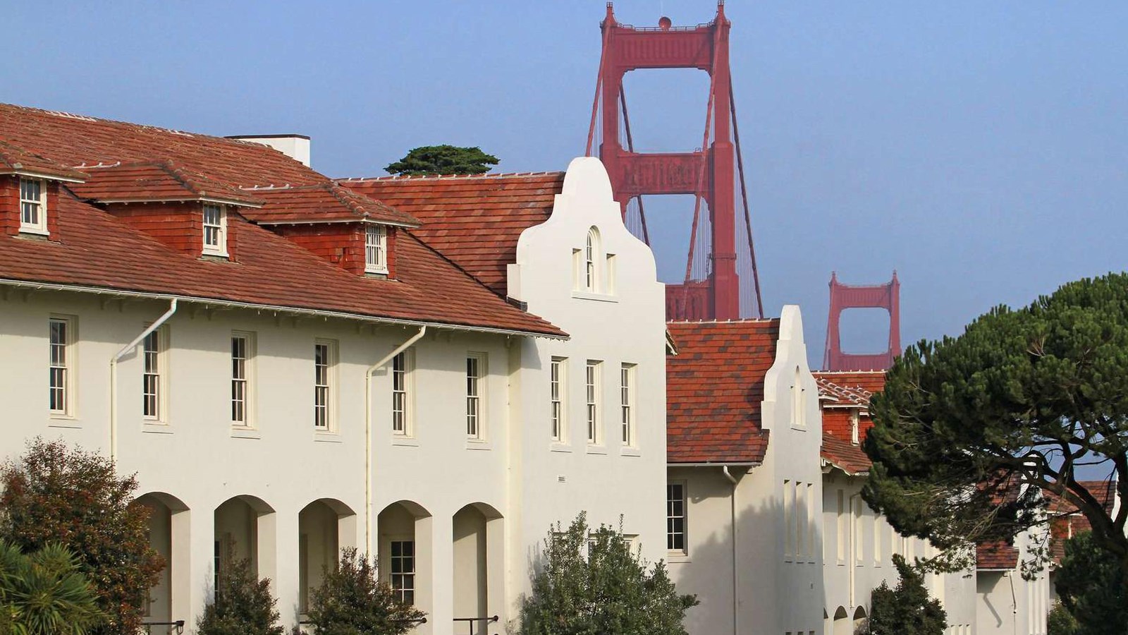 Mission revival style buildings of Fort Scott with the Golden Gate Bridge in the background.