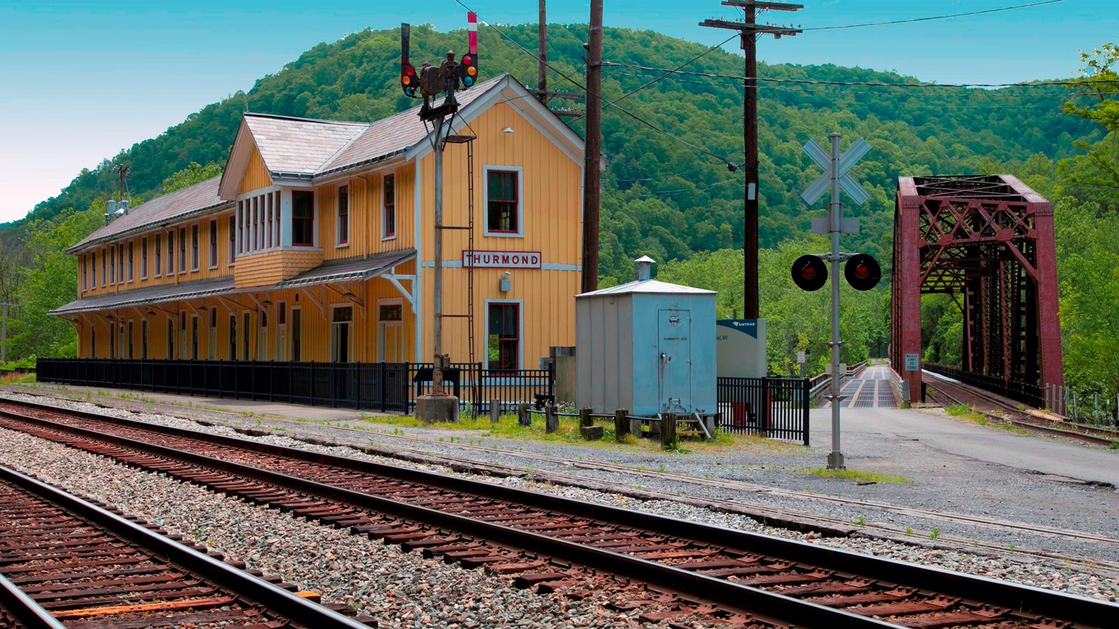 yellow railroad depot and train tracks
