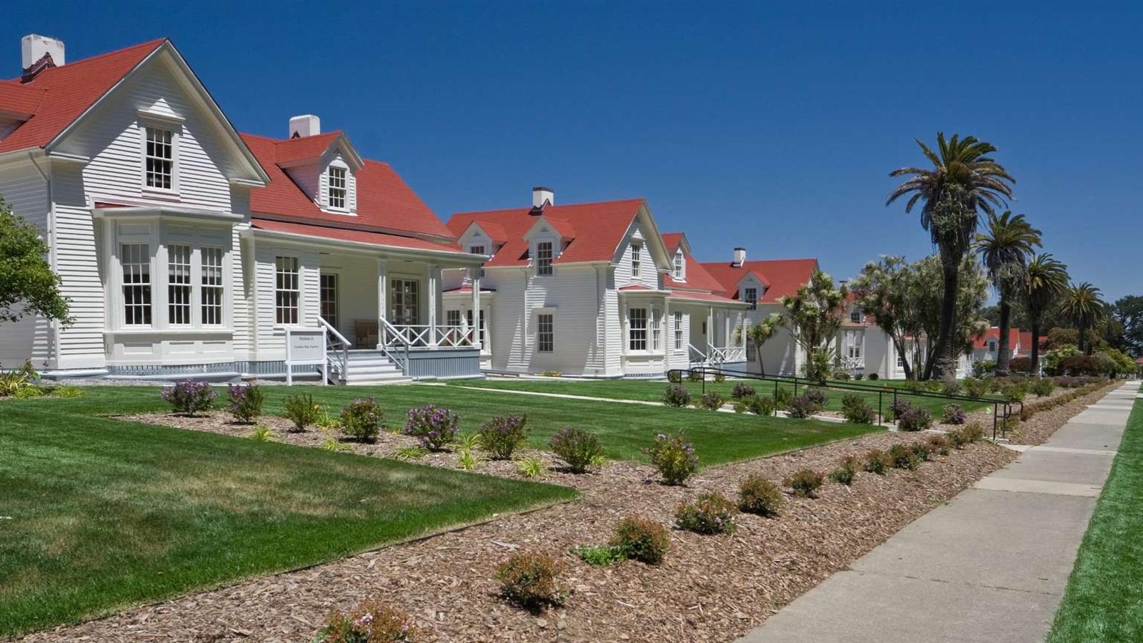 The row of Funston Avenue homes as they appear today, with white wood sides and red roofs.