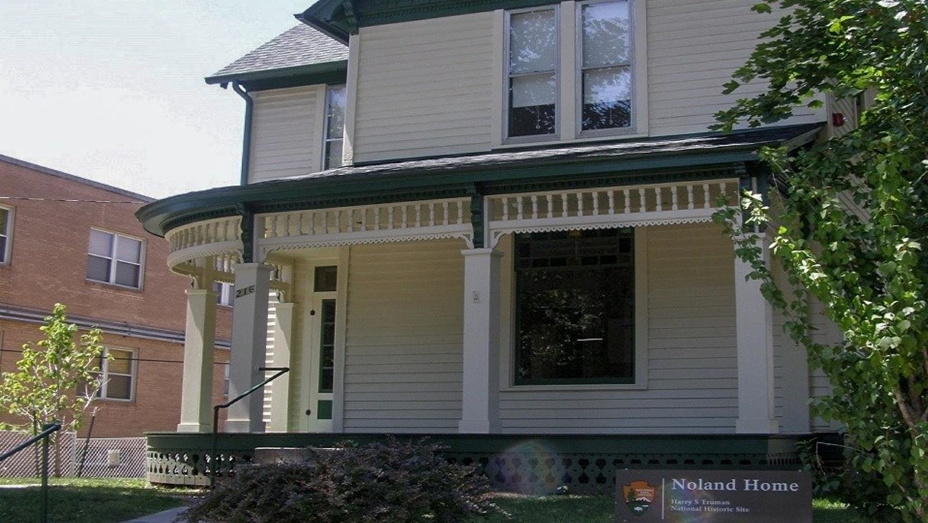 Green and yellow Victorian home with steps