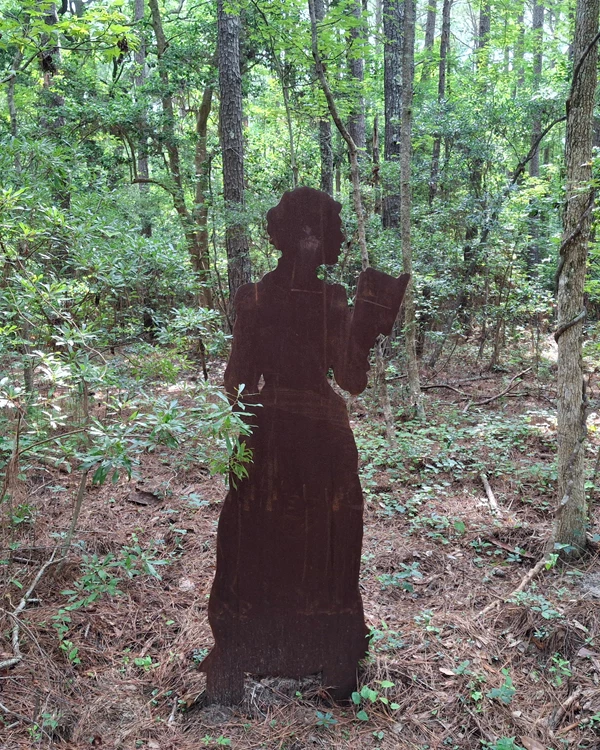 A rust-colored silhouette of an adult woman reading a book