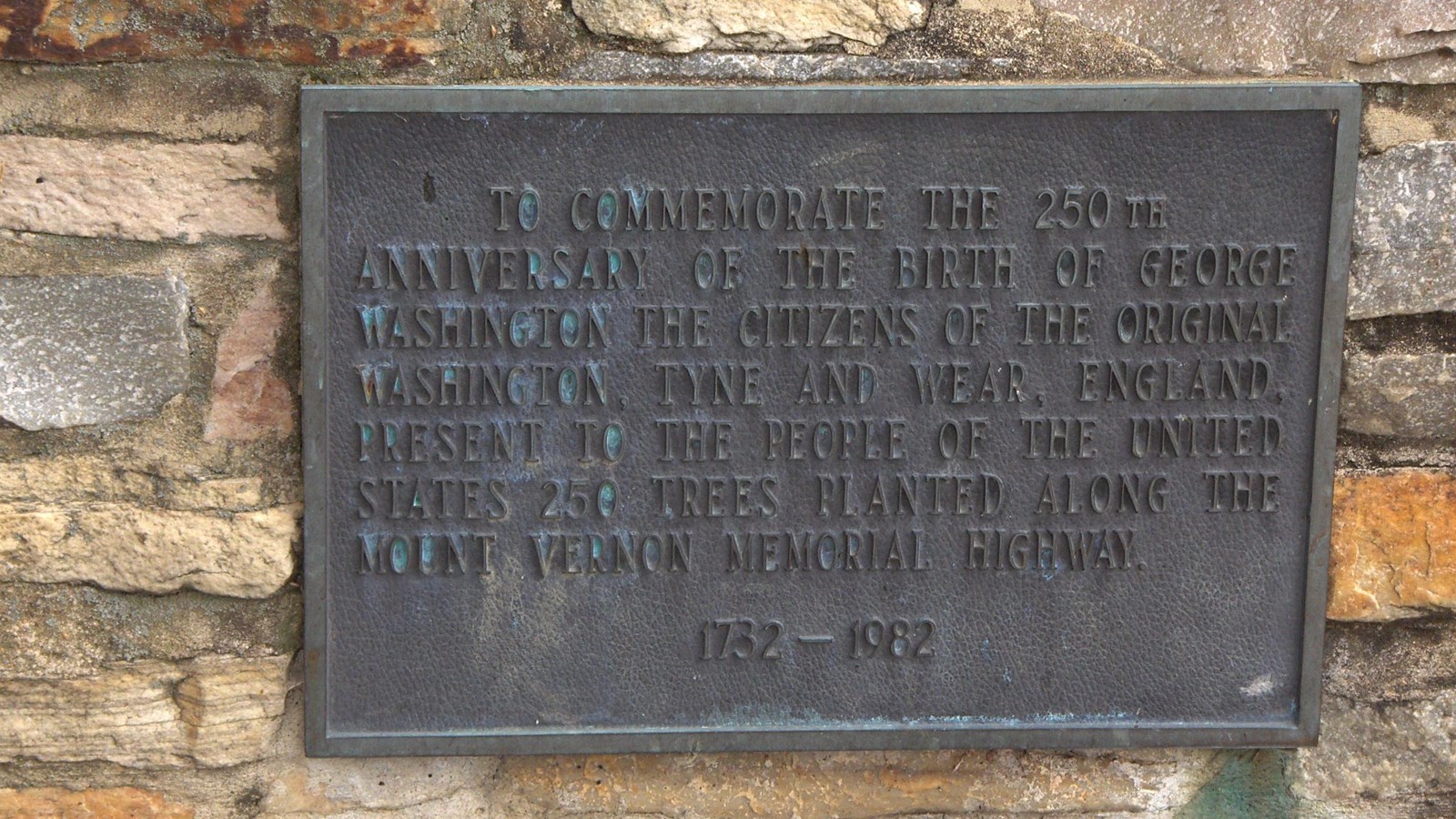 A plaque attached to some stones.