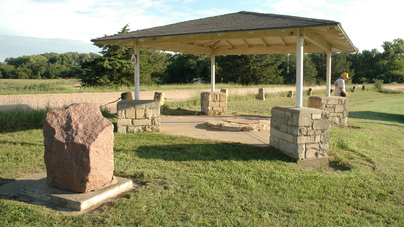 A granite marker and a ground well covered with a portico