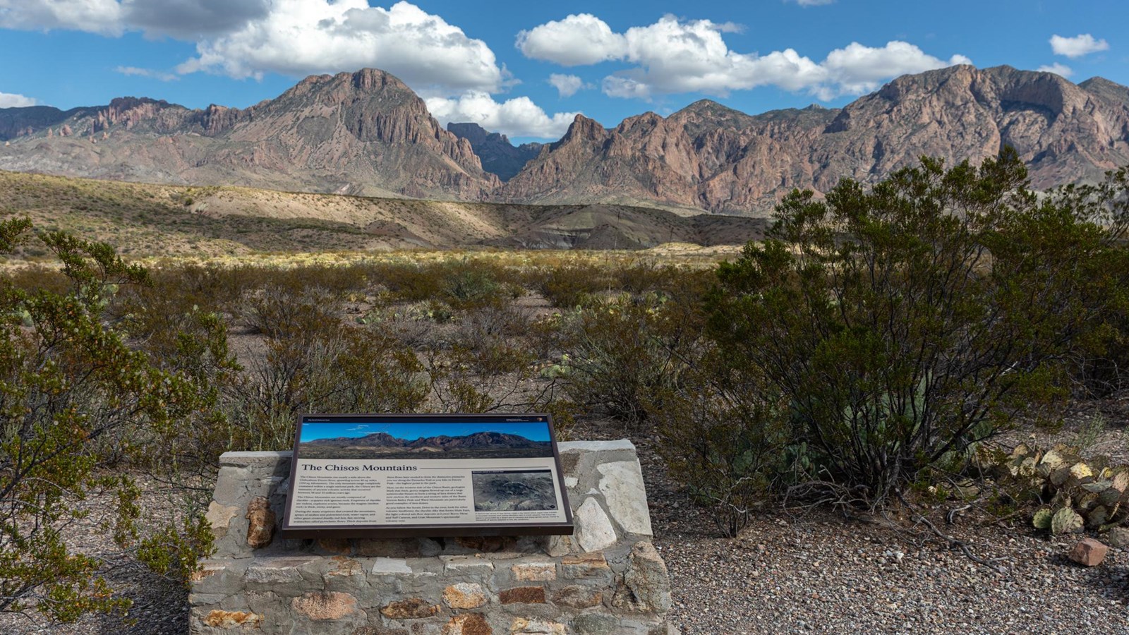 Wayside describing formation of Chisos Mountains with mountains in the background.