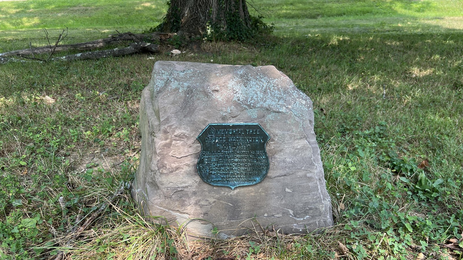 A plaque attached to a small boulder.