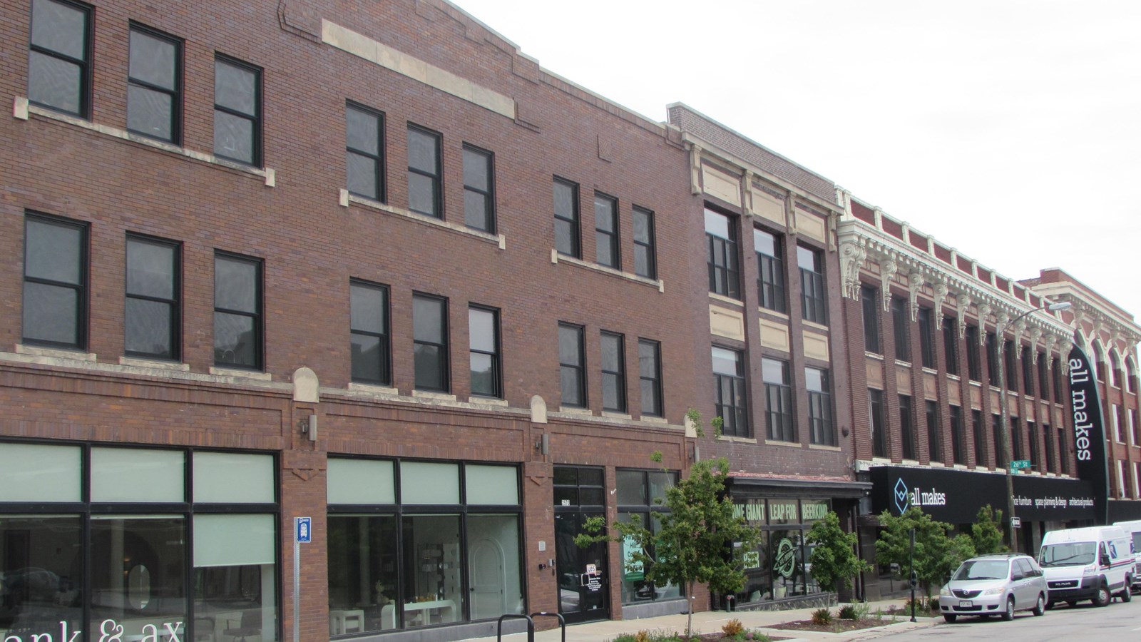 Three and four story brick commercial buildings. Large storefronts and windows across upper floors