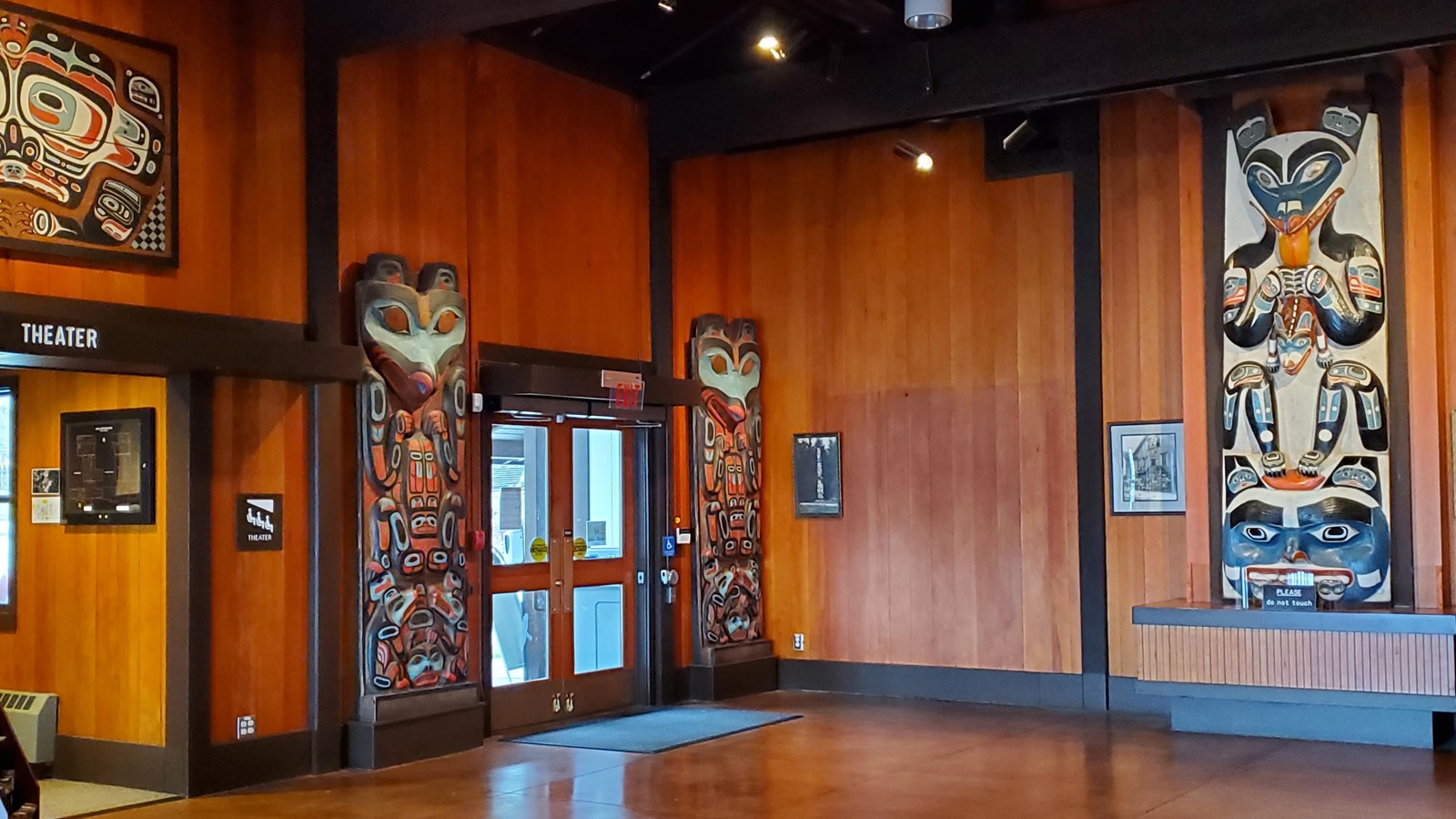 Entrance doors flanked by Tlingit carvings on either side.