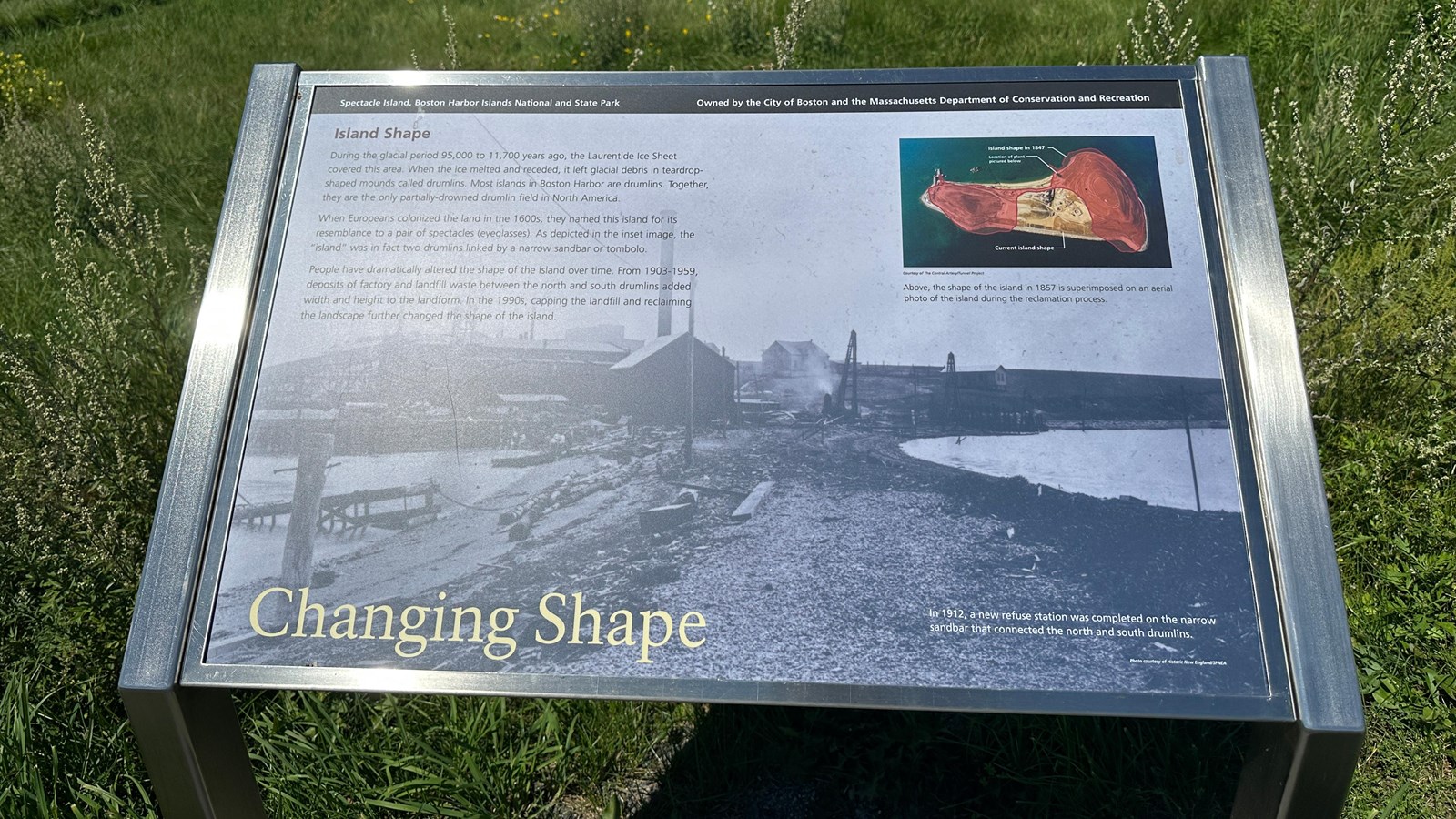 Photo of a metal wayside with a black and white image and a column of text on it