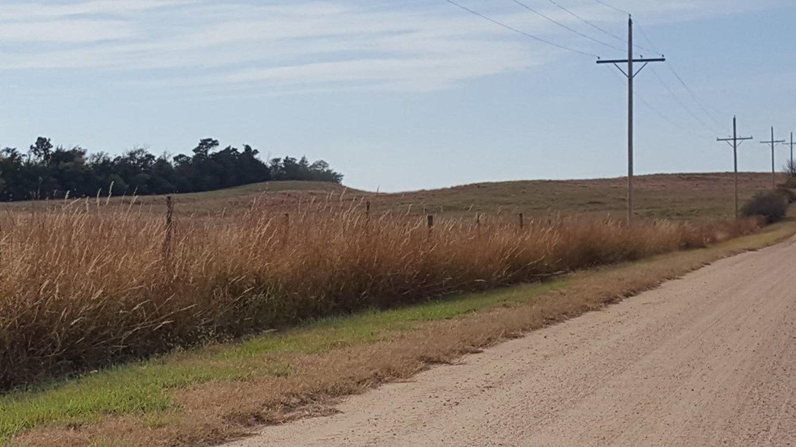 A grassy field with a visible depression in a ridge 