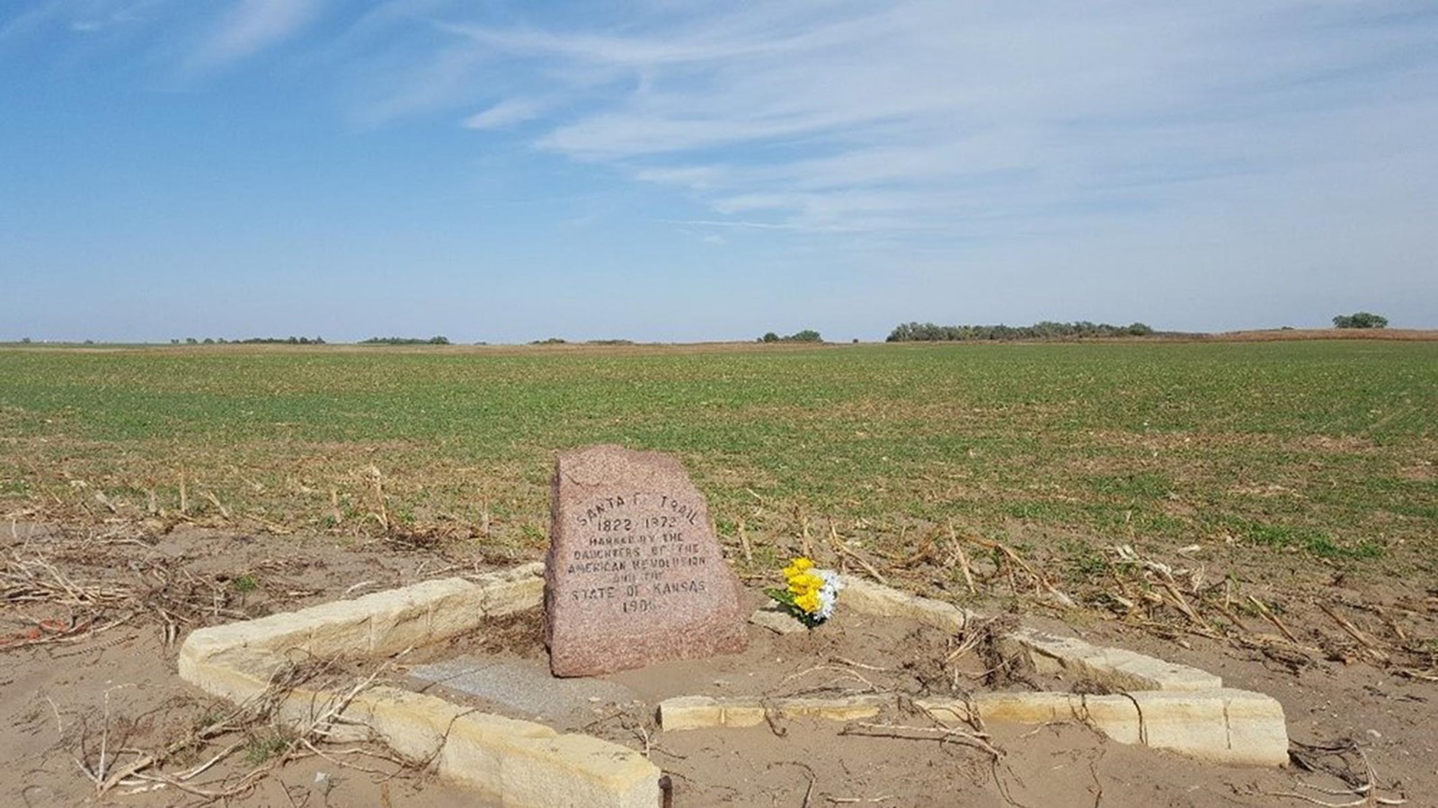 A granite marker in a grassy field