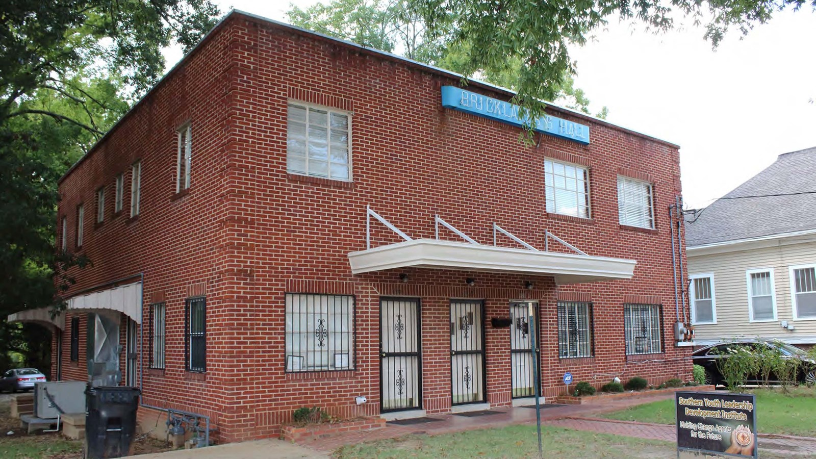 The two-story brick building rests on a concrete slab foundation and has 3 entrance doors. 