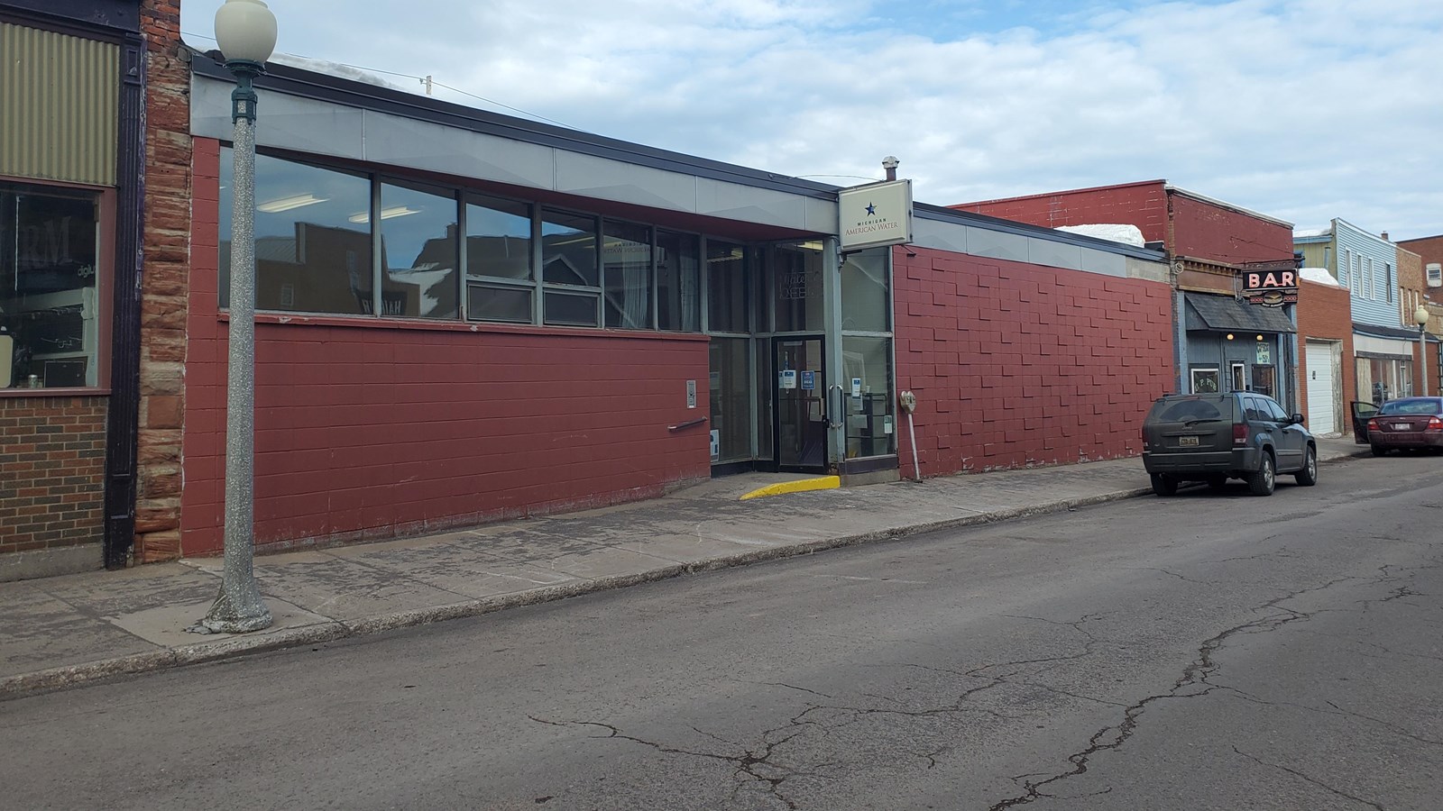 Single story concrete block building painted red. Sign above the door reads Michigan American Water.