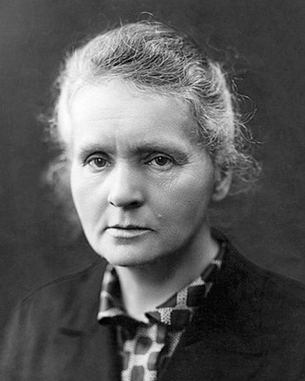 Black and white photo of Marie Curie seated in front of the camera.