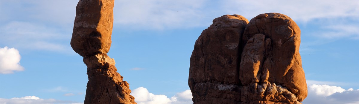 a tall boulder sits on a stone pedestal
